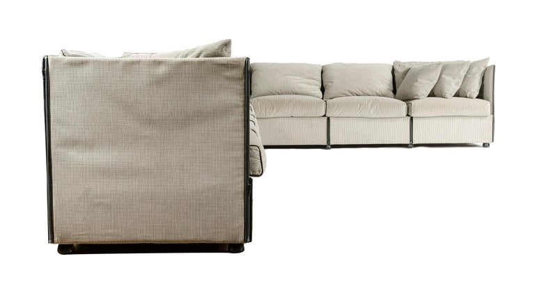 A Mid-Century Modern nine (9) piece modular sectional designed by Mario Bellini. This sofa is upholstered in grey textured fabric and leather accents. The pieces can be configured as a small sectional with a separate sofa. Made in Italy by Cassina,
