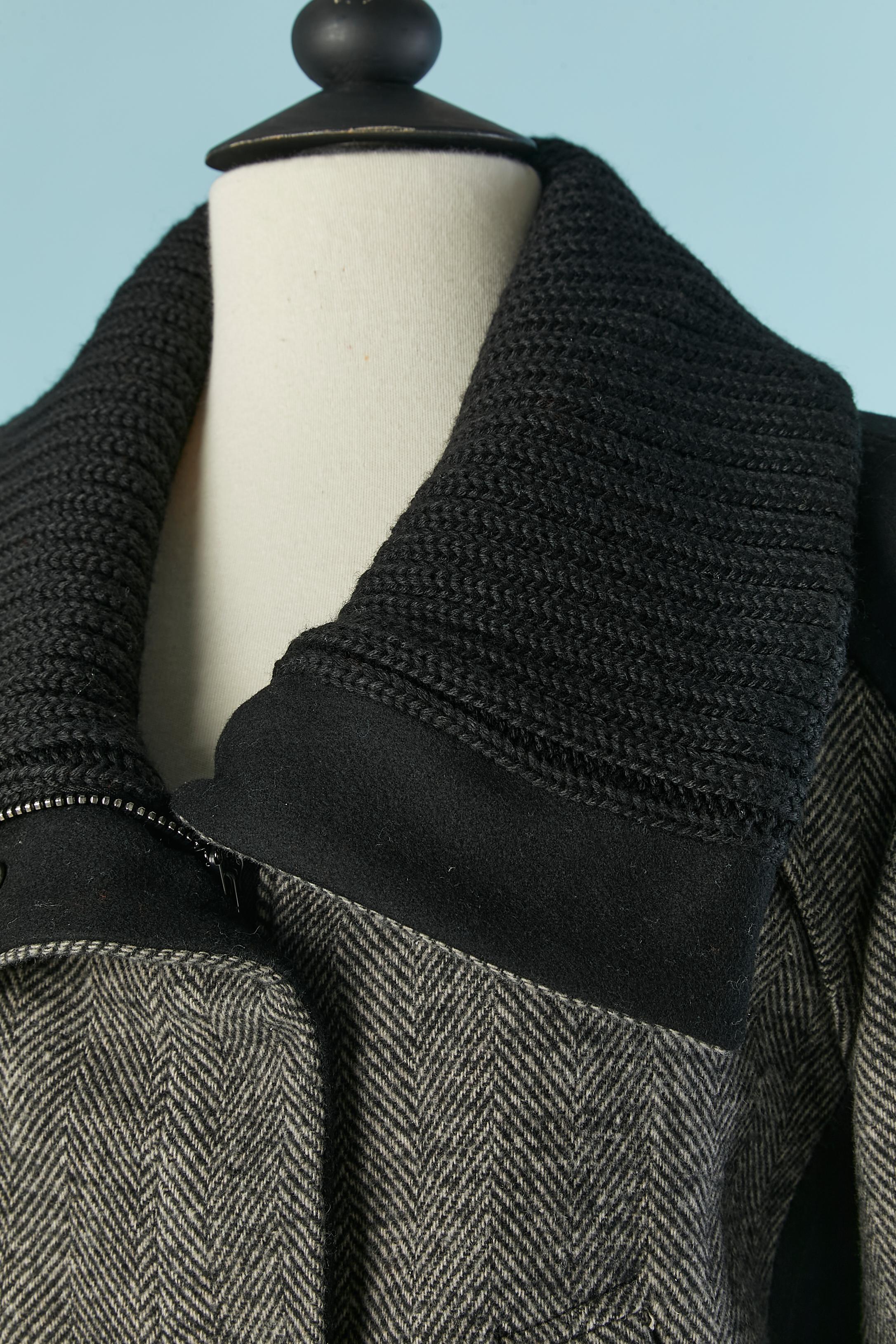 Cappotto grigio con motivo chevron e colletto a costine in maglia. Composizione del tessuto della scocca: 47% acetato, 27% poliestere, 19% lana, 5% altre fibre, 2% rayon. Composizione del bordo: 80% lana, 20% poliestere. Fodera: 65% poliestere, 35%