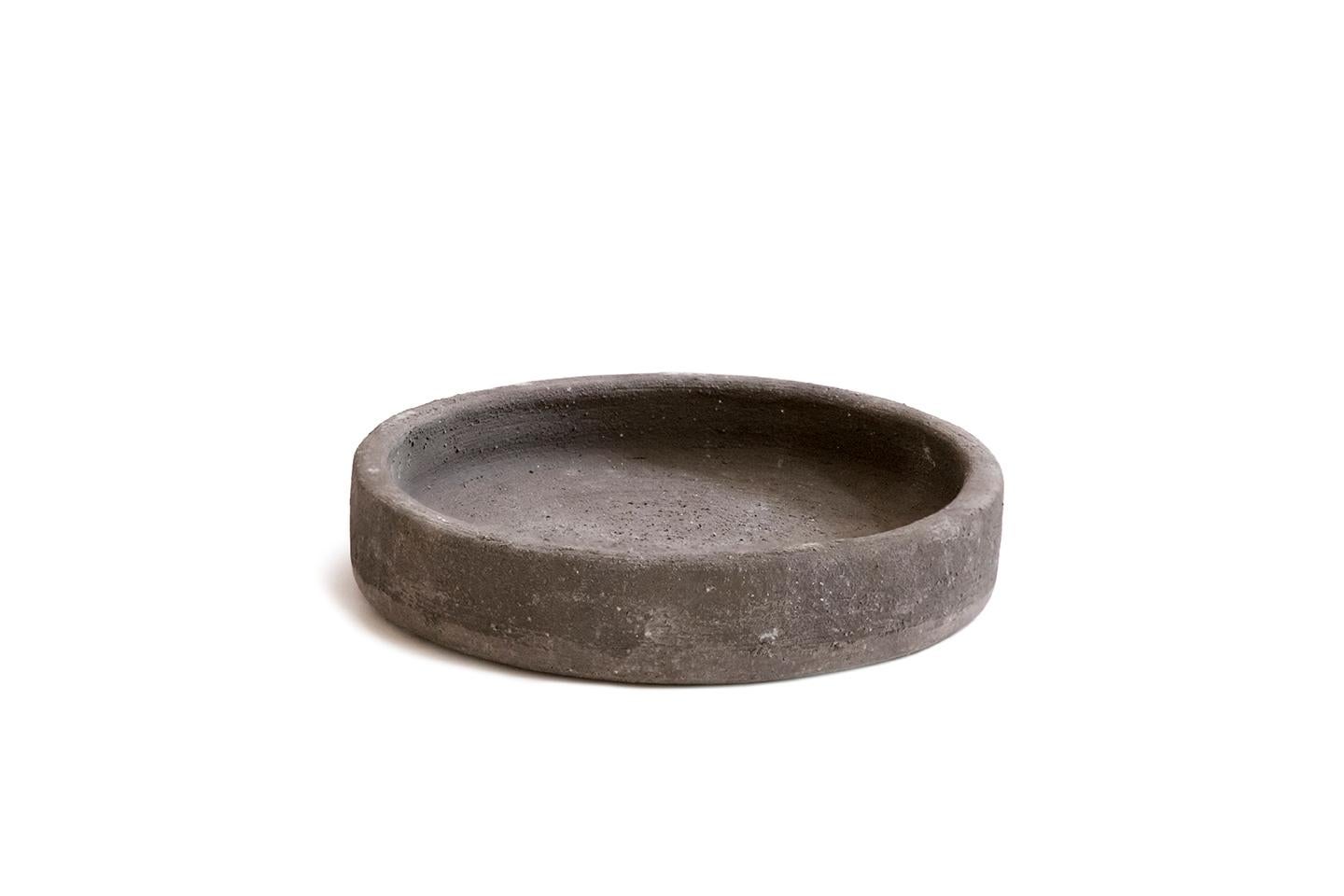 Ciotola Diogenèa in argilla grigia di Studio A
Dimensioni: D. 23 x H. 4,8 cm
Materiali: Argilla grigia.

Un numero di 31 ciotole di forma identica, realizzate in edizione limitata da raffinati artigiani italiani in 31 materiali diversi: Diogenèa -