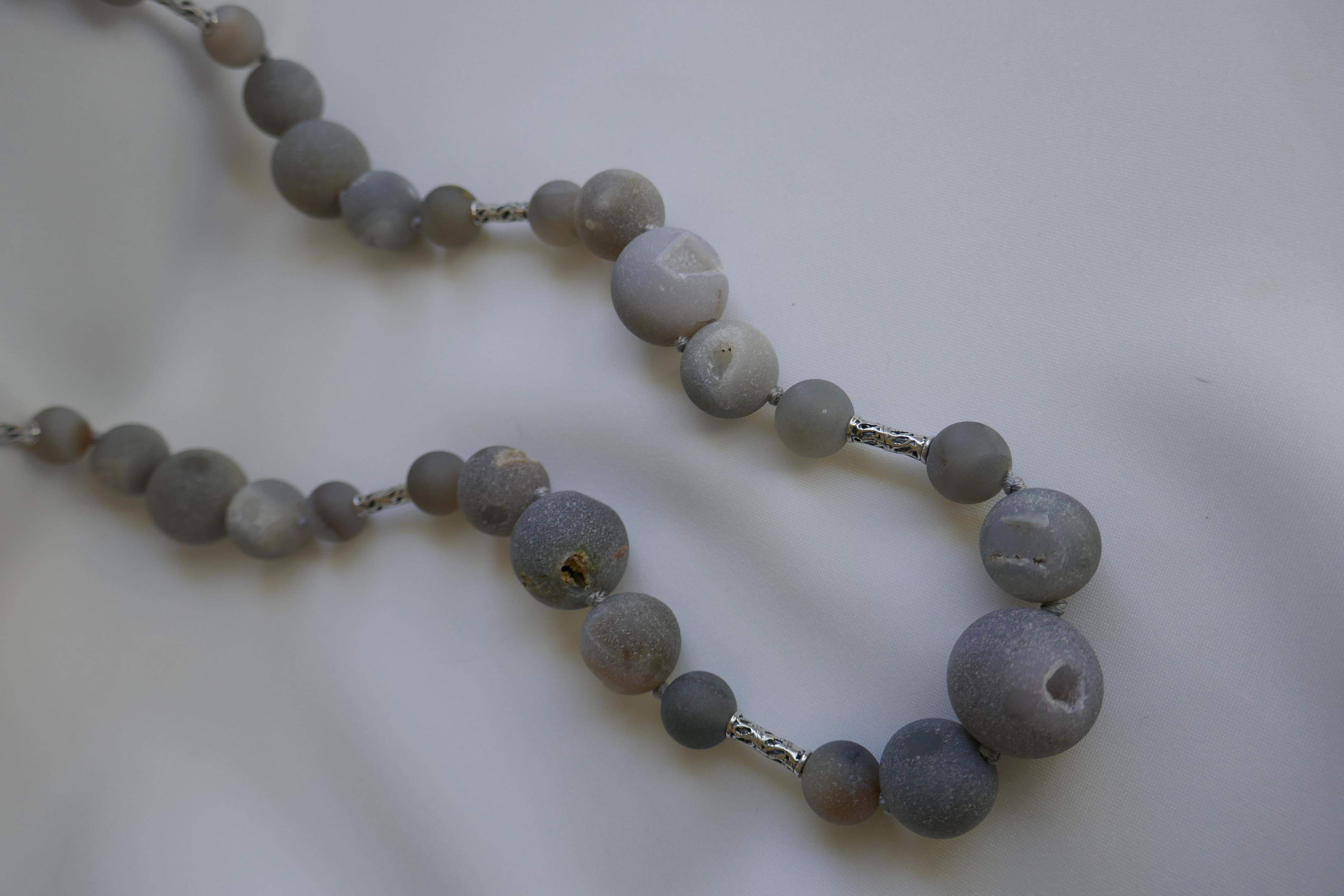 The grey druzy quartz beads are in three different sizes 200mm, 16mm, and 12mm. They are interspersed with carved sterling silver tubes and also has a 925 sterling silver clasp.  The color of these stones make it very wearable year round. It may be