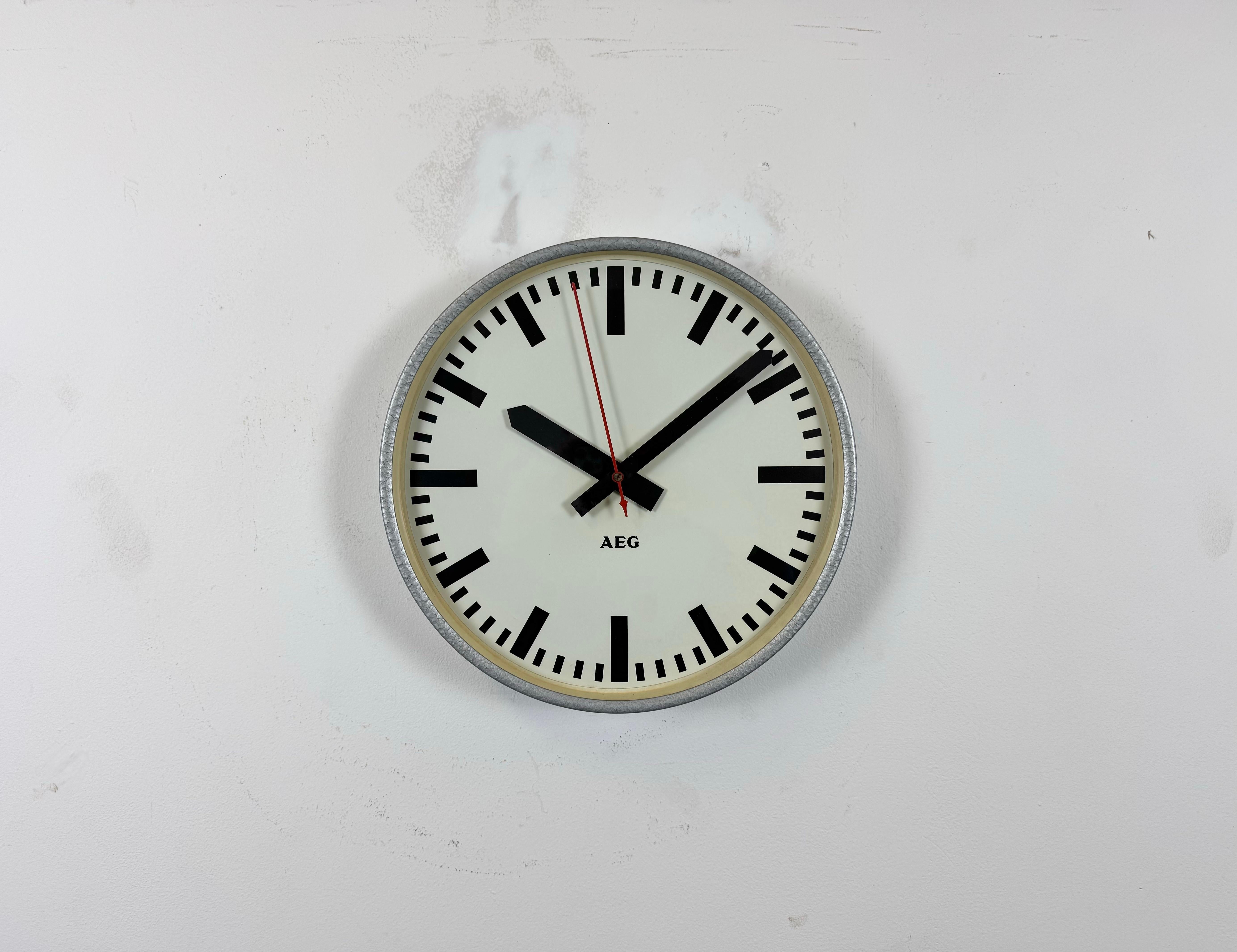 This wall clock was produced by AEG in Germany during the 1960s. It features a grey hammerpaint iron frame, a metal dial and a clear glass cover. Original electric movement ( 220 V ) works perfectly. The weight of the clock is 1,3 kg.
The diameter