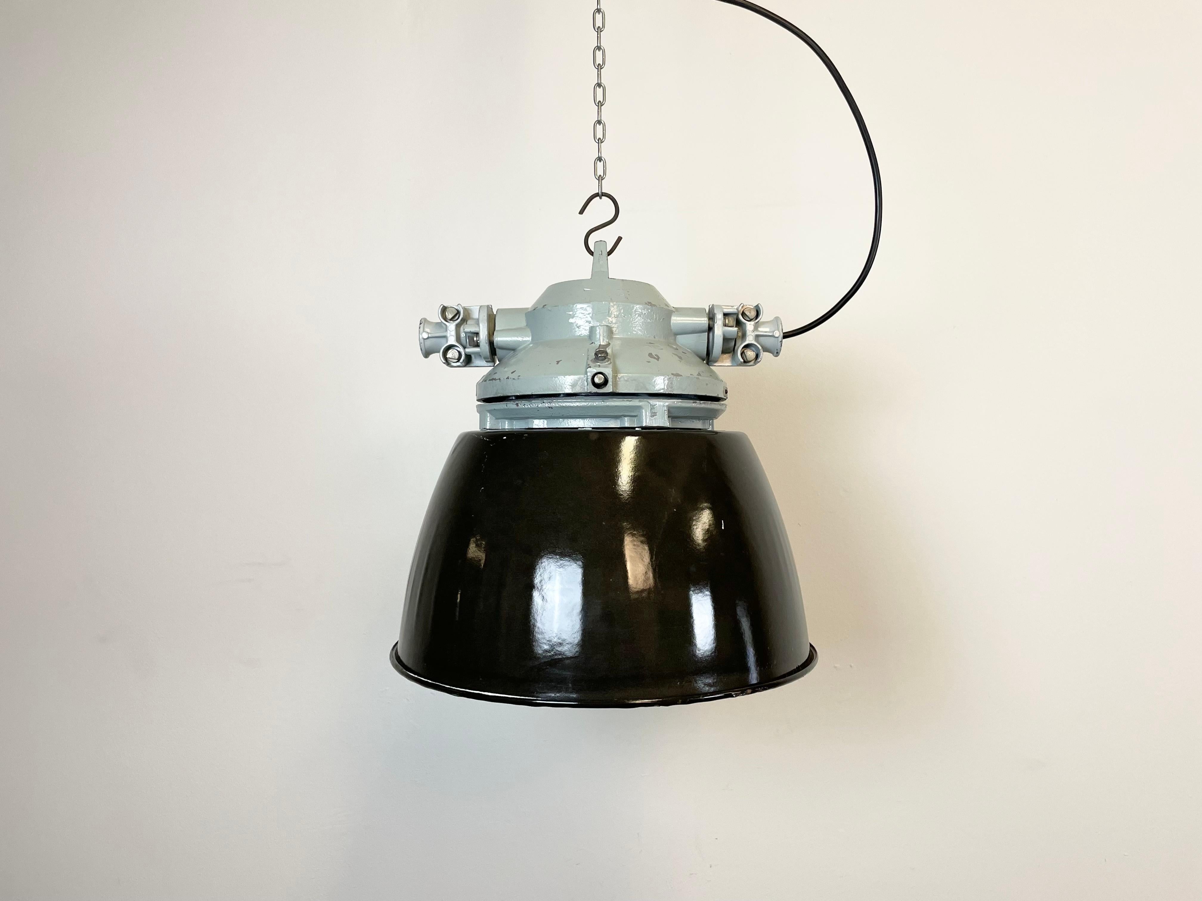 Grey industrial light with massive protective glass bulb. Cast aluminium body, clear glass. Black enameled shade with white interior. Porcelain socket for E27 light bulbs. Newly wired. Weight: 8 kg.