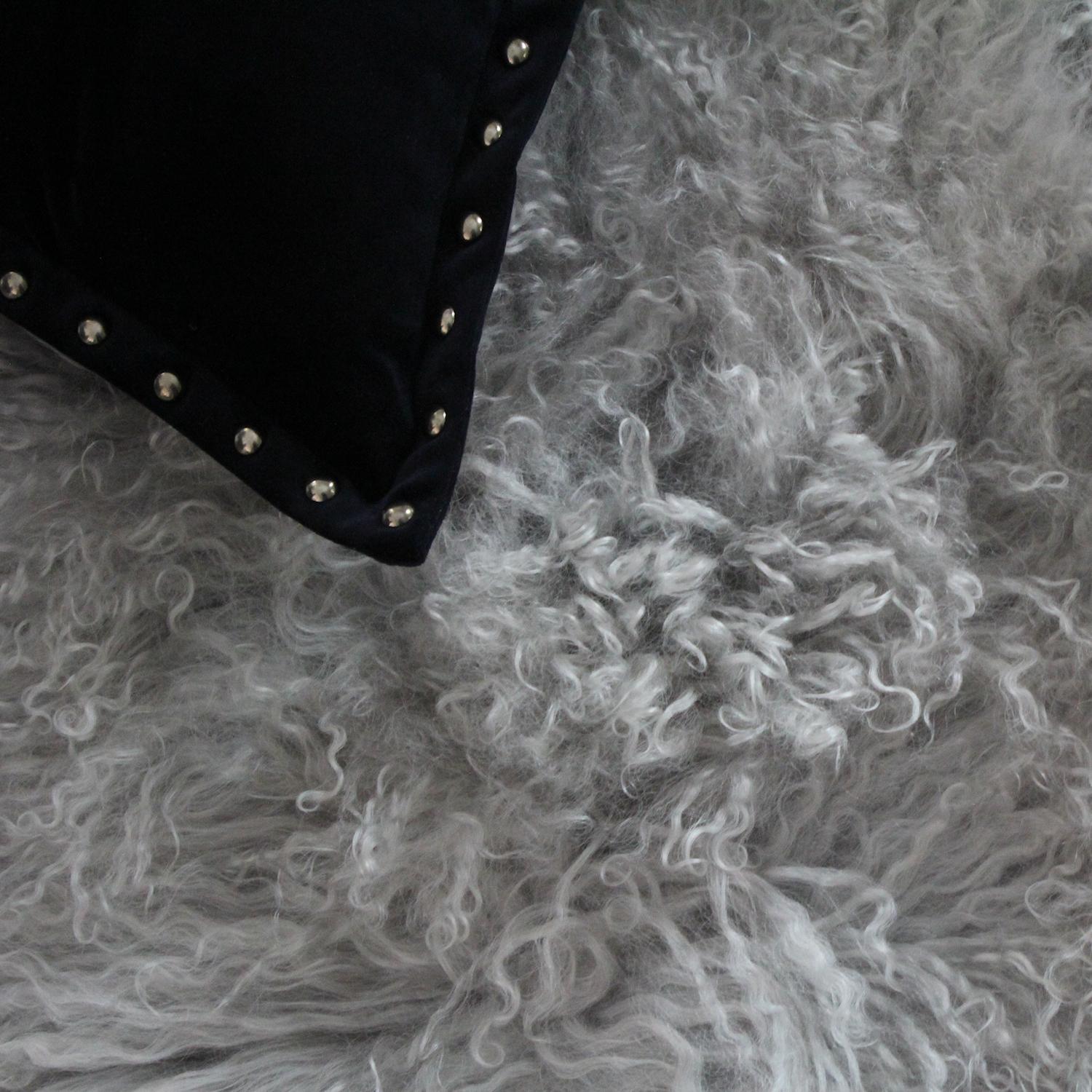 Este puf de piel de mongol gris claro se verá y se sentirá muy exuberante en cualquier interior, ya sea en un salón para sentarse o para dar comodidad a los pies o para añadir un poco de glamour a un dormitorio. Cada otomana de piel de Mongolia