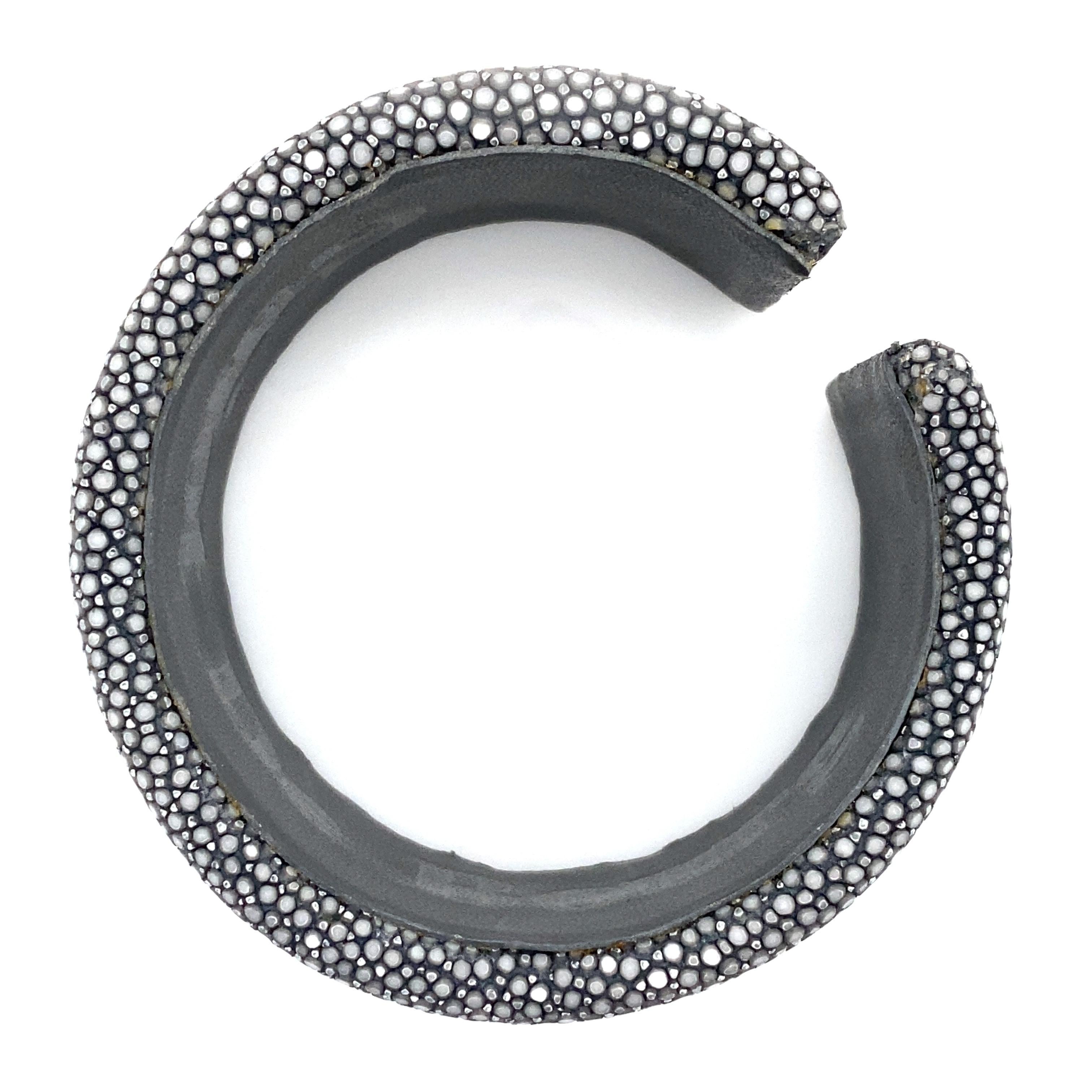 Sumptuous cuff bracelet in grey shagreen. Carefully crafted, this incredibly chic bracelet is a perfect marriage of traditional craftsmanship and contemporary design.

Grey shagreen, a rare and precious material, is used to create this unique piece.