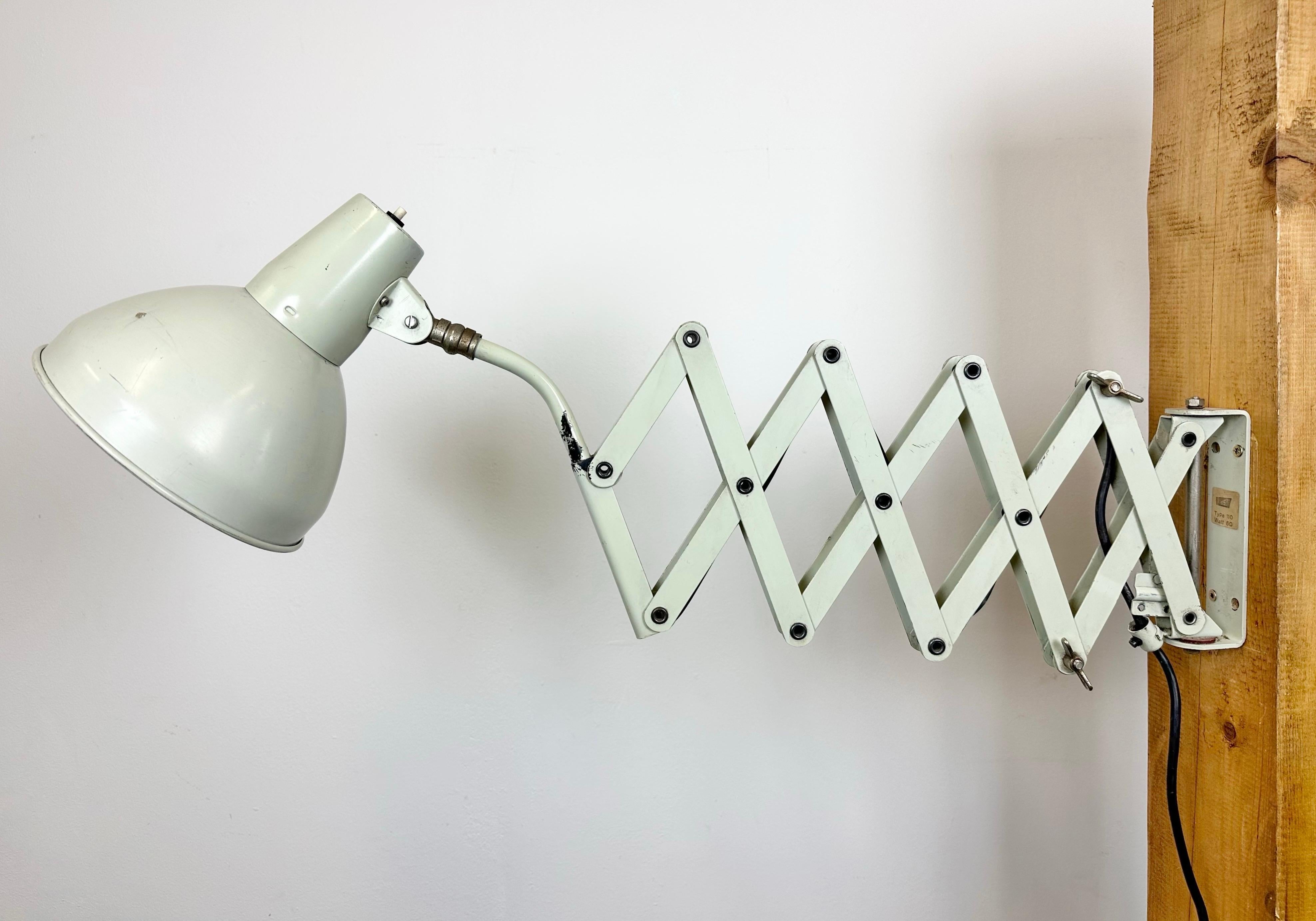 Industrial scissor wall lamp manufactured by SIS in Germany during the 1960s. The lamp has a metal shade. The iron scissor arm is extendable and can be turned sideways.The swich is situated directly on the shade.The socket requires E27/ E26 light