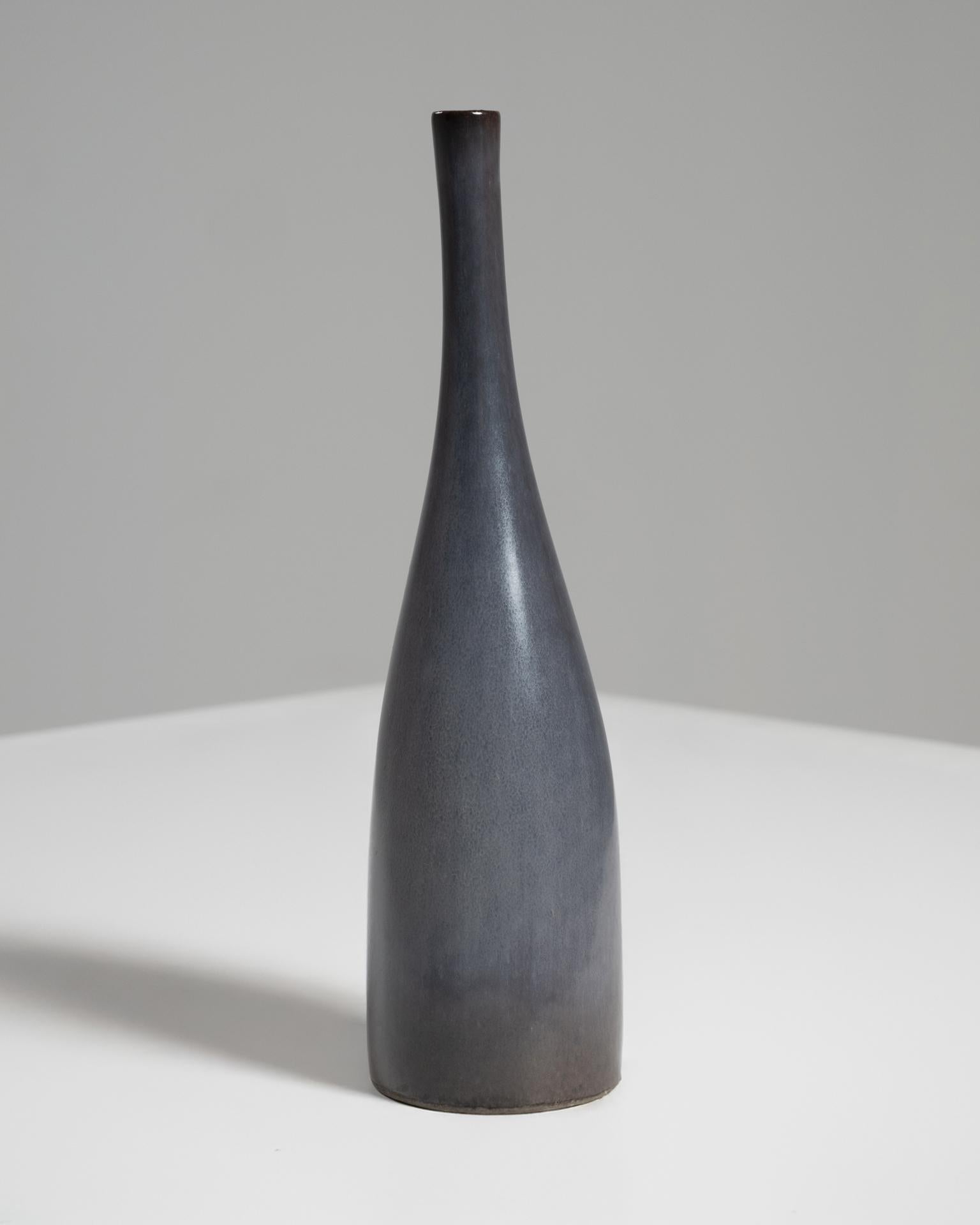 Esta refinada botella de cerámica esmaltada gris fue creada por los célebres ceramistas franceses Jacques (1926-2008) y Dani (1933-2010) Ruelland, cuyo trabajo en colaboración en las décadas de 1950 y 1960 ayudó a definir la moderna cerámica