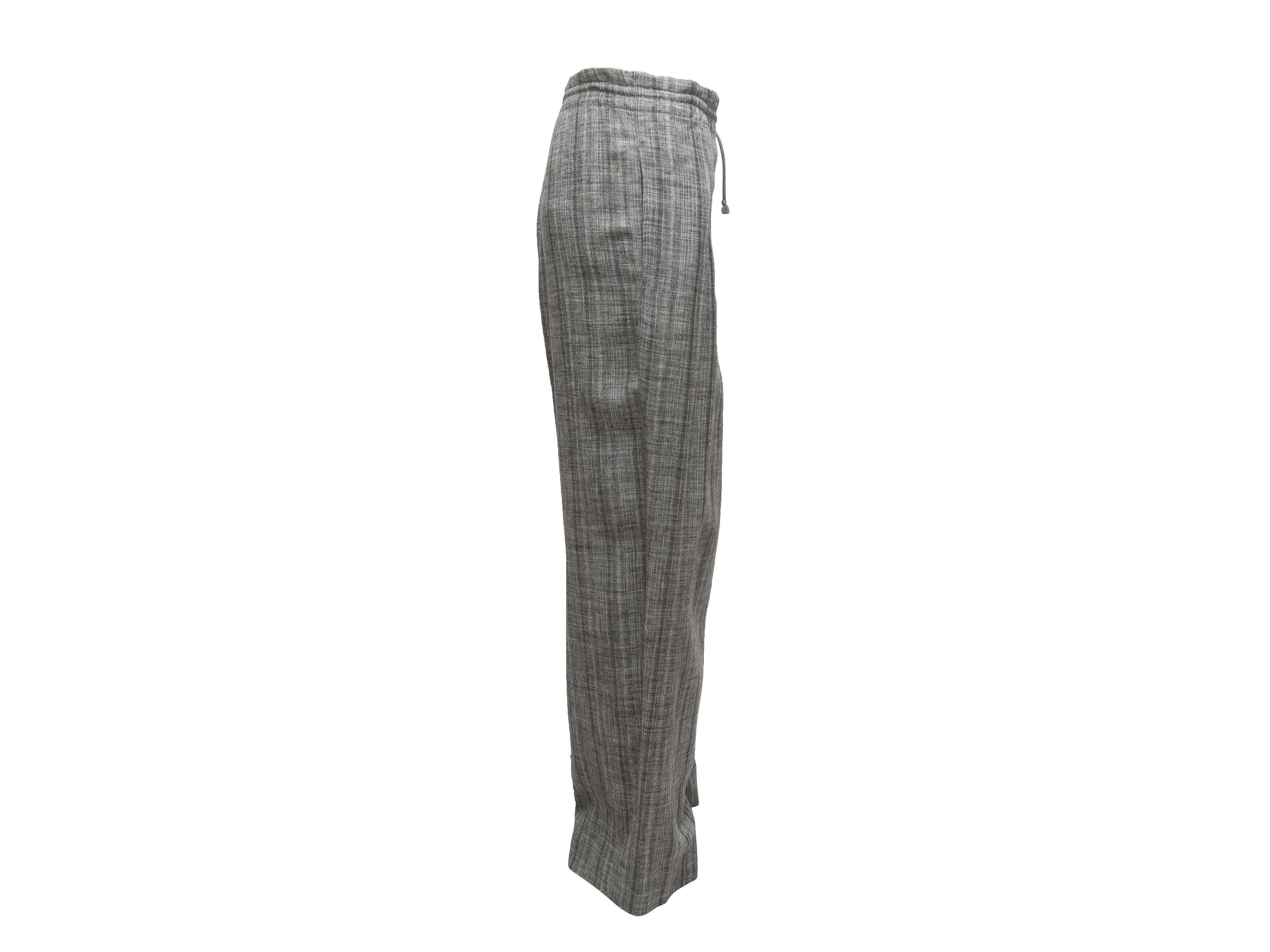 Grey wide-leg pants by Hermes. Dual hip pockets. Drawstring at waist. Button closures at front waist. 41