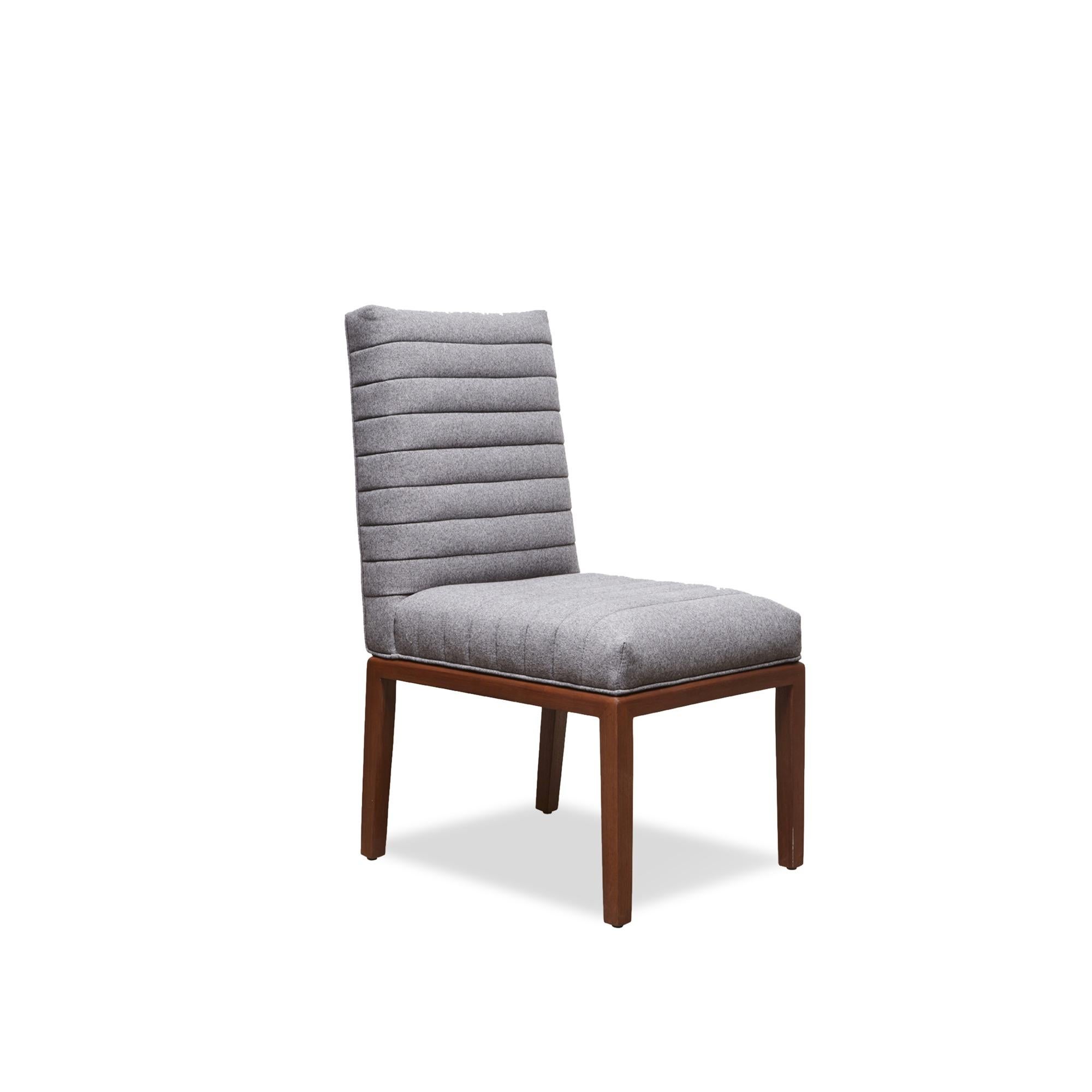 The highback shoreland chair is part of the collaborative collection with interior designer Brian Paquette. The dining chair features a channel tufted back and seat with a solid American walnut or white oak frame. This piece is available in