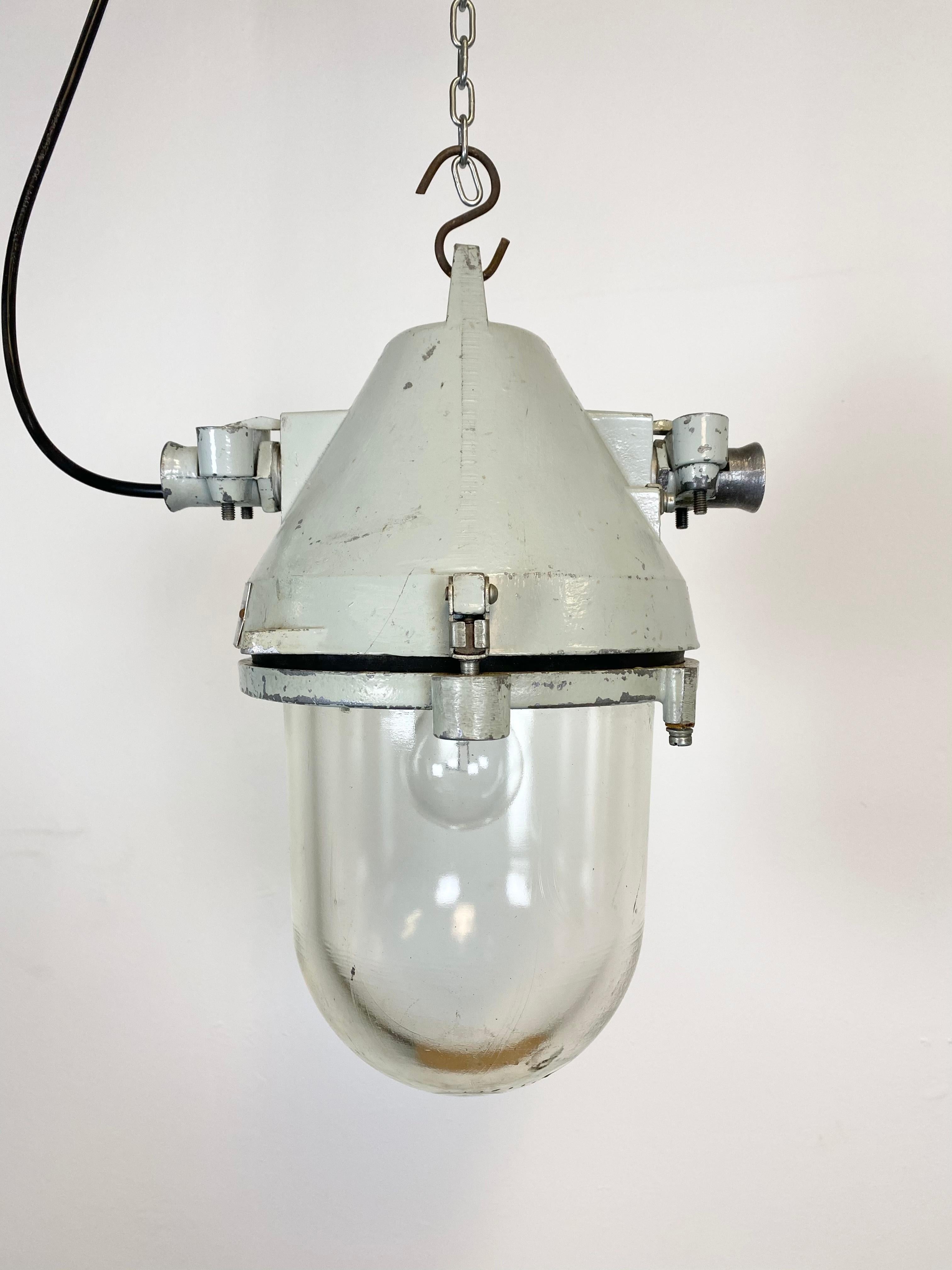 Grey industrial explosion proof light with massive protective glass bulb. Made in former Czechoslovakia by Elektrosvit during the 1970s.It features a cast aluminium body and a clear glass cover. Original porcelain socket requires standard E27/ E26