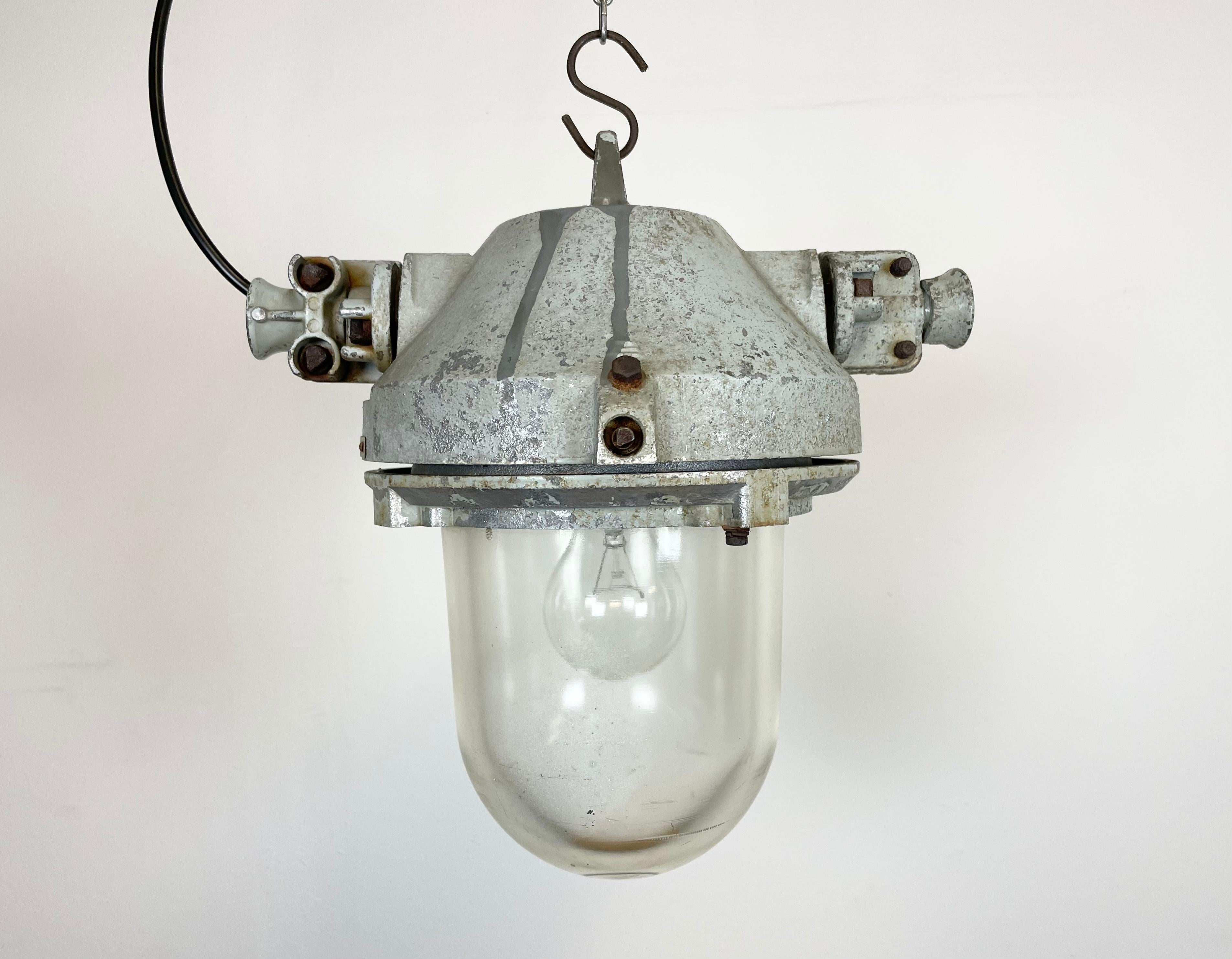 Grey industrial light with massive protective glass bulb. Made in former Czechoslovakia by Elektrosvit during the 1970s. It features cast aluminium body and clear glass. Porcelain socket requires E27 lightbulbs. Newly wired. Weight: 9 kg.