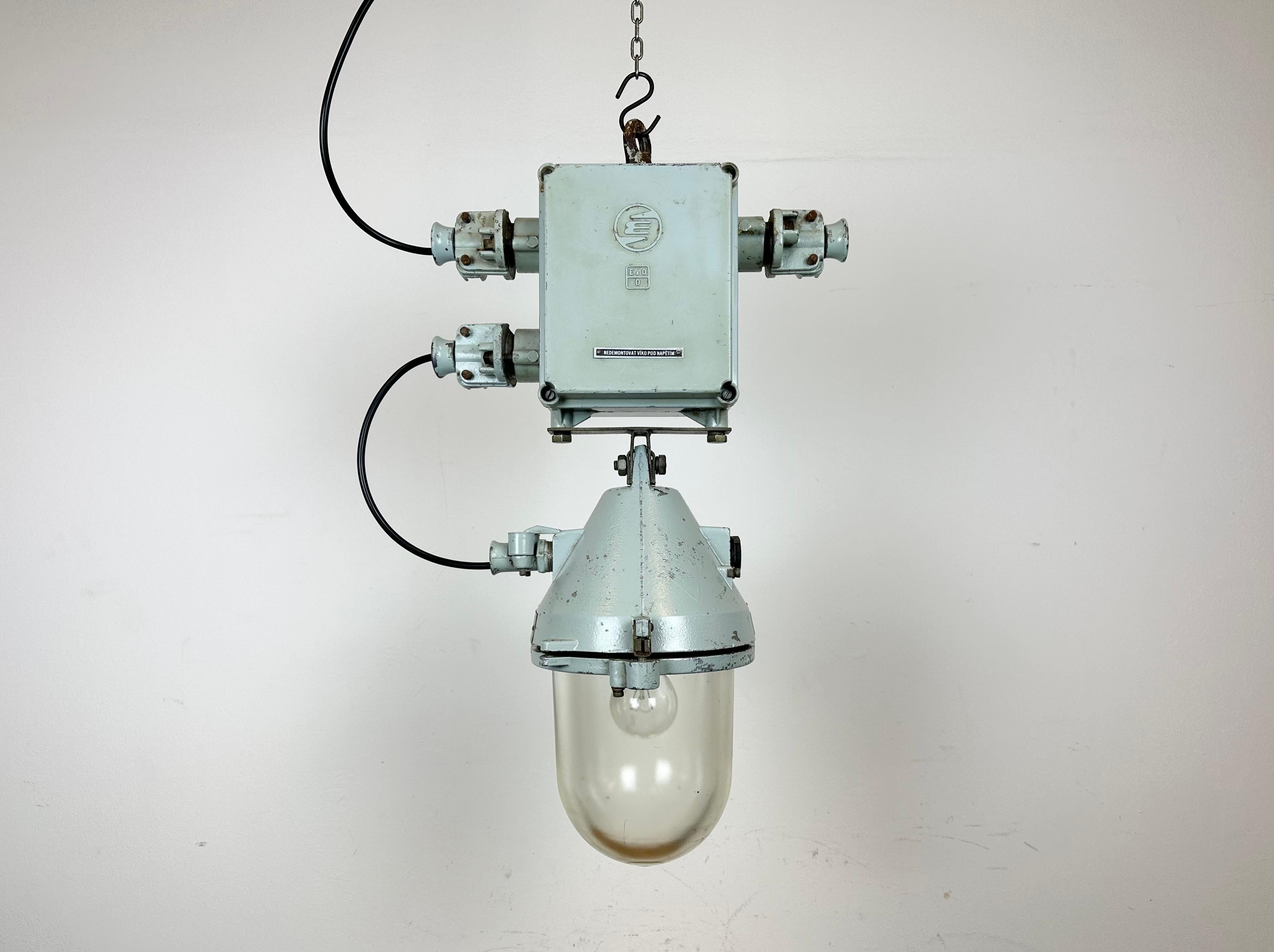 Grey industrial explosion proof light with massive protective glass bulb. Made in former Czechoslovakia by Elektrosvit during the 1970s. It features a cast aluminium body and a clear glass cover. The original porcelain socket requires standard E27/
