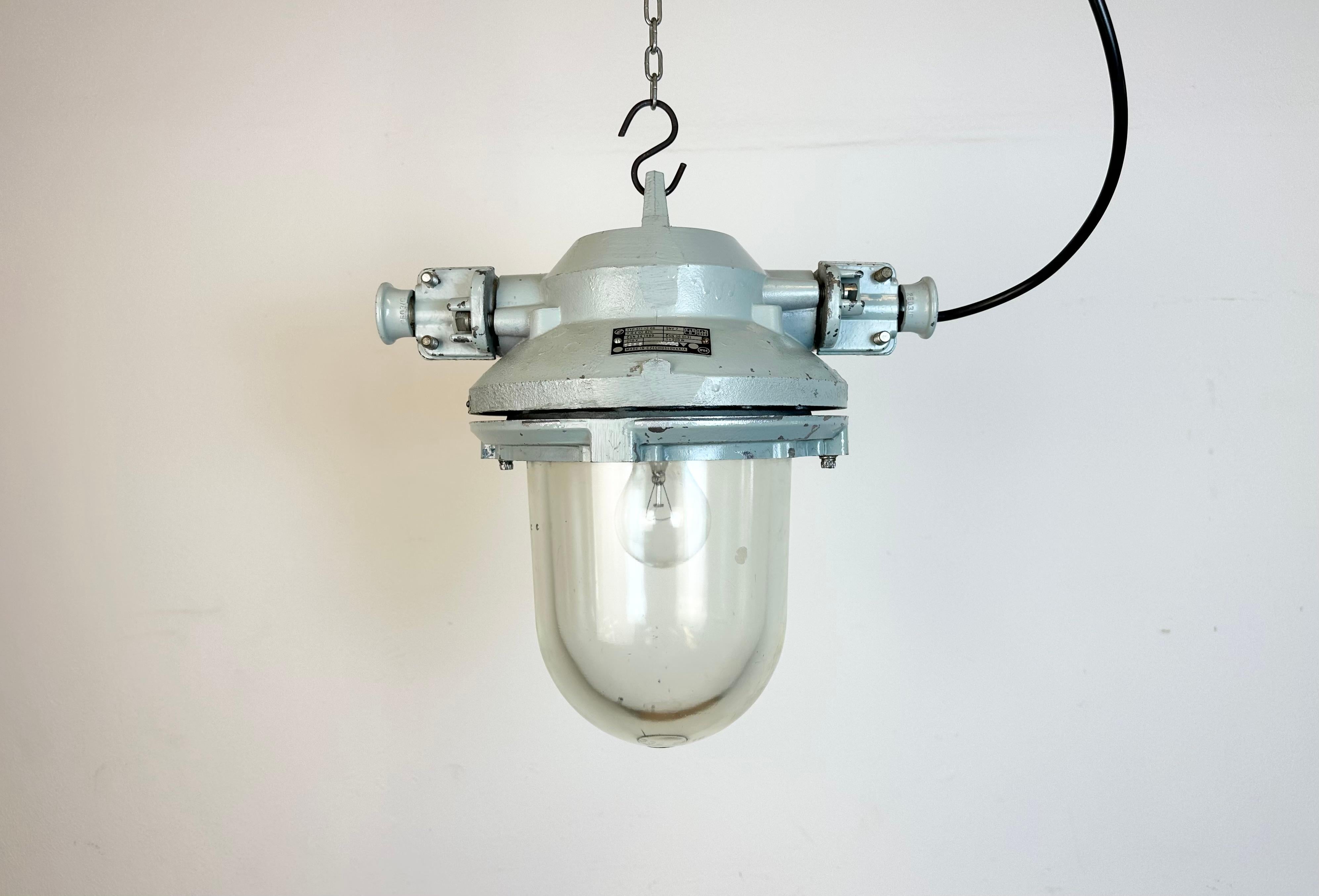 Luminaire industriel gris avec ampoule en verre massif de protection. Fabriqué dans l'ancienne Tchécoslovaquie par Elektrosvit dans les années 1970. Il se compose d'un corps en aluminium moulé et d'un verre transparent. La douille en porcelaine
