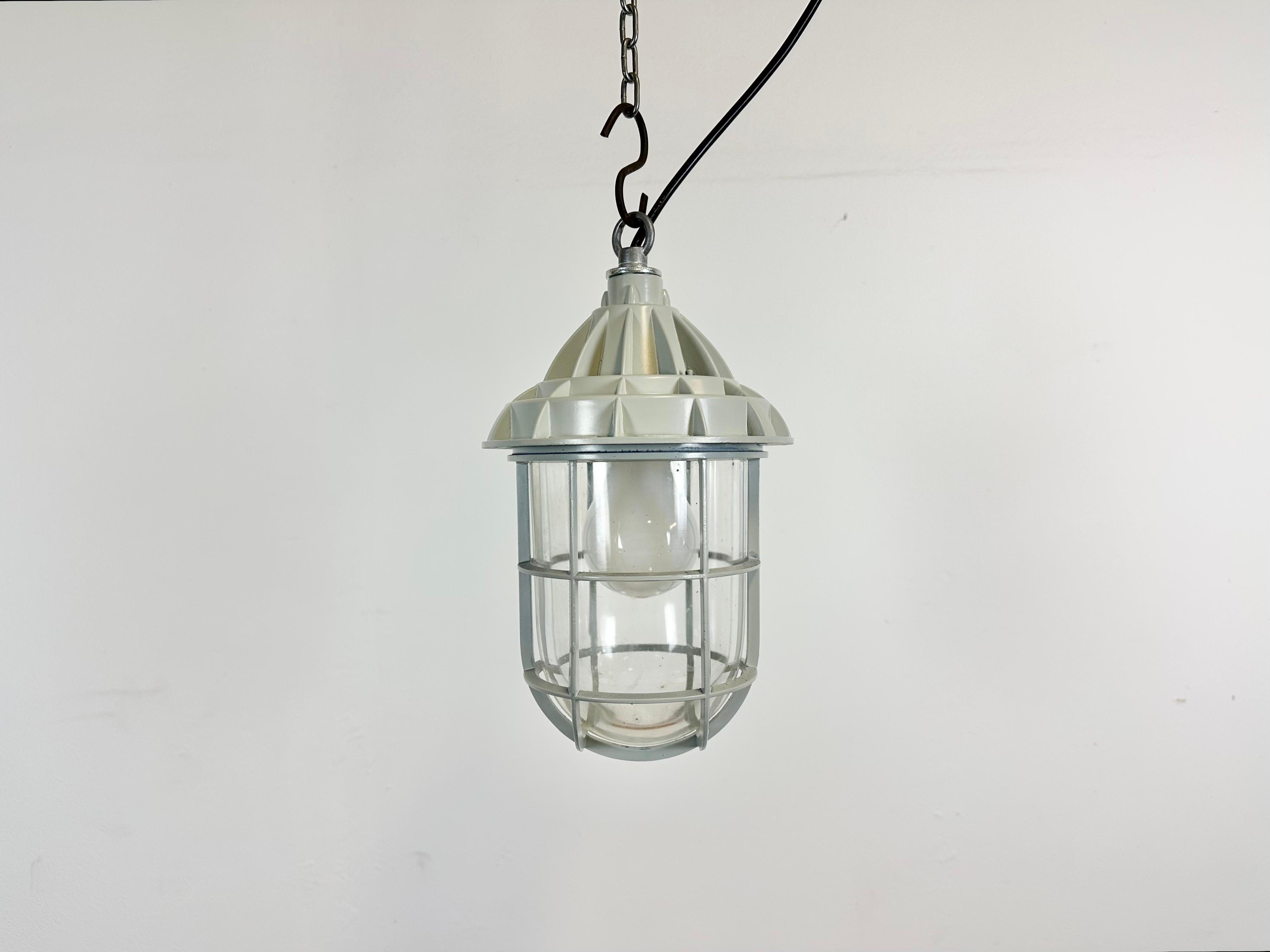 Induatrial cage pendant light made by Yamada Co.Ltd. in Japan during the 1960s. It features a cast aluminium body and a clear glass cover. The socket requires E 26/ E 27 light bulbs. The weight of the light is 1.9 kg.