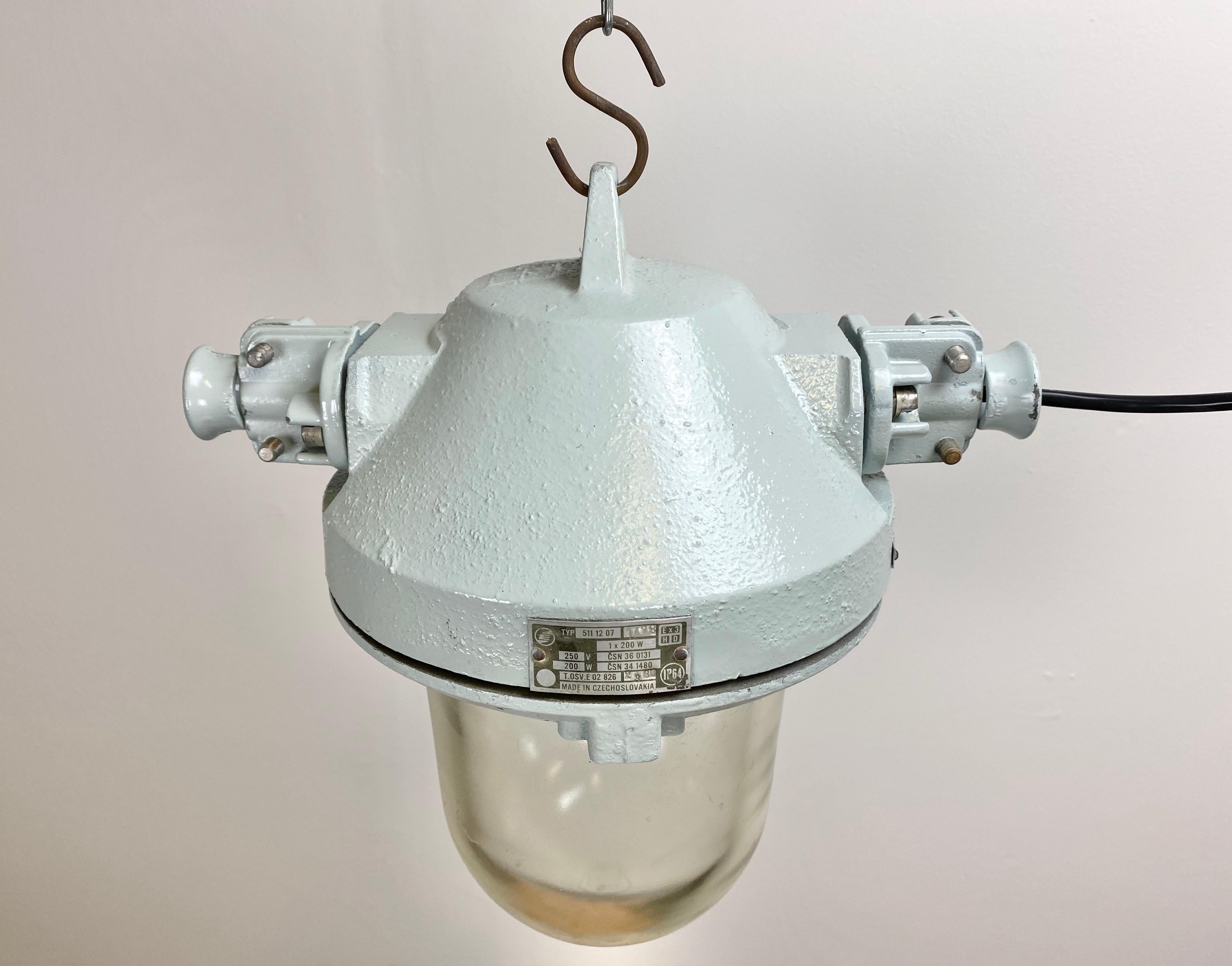 Cette lampe industrielle a été fabriquée par Elektrosvit dans l'ancienne Tchécoslovaquie au cours des années 1970. La lampe a un corps en aluminium moulé gris et une ampoule en verre transparent de protection massive. Il est doté d'une douille en