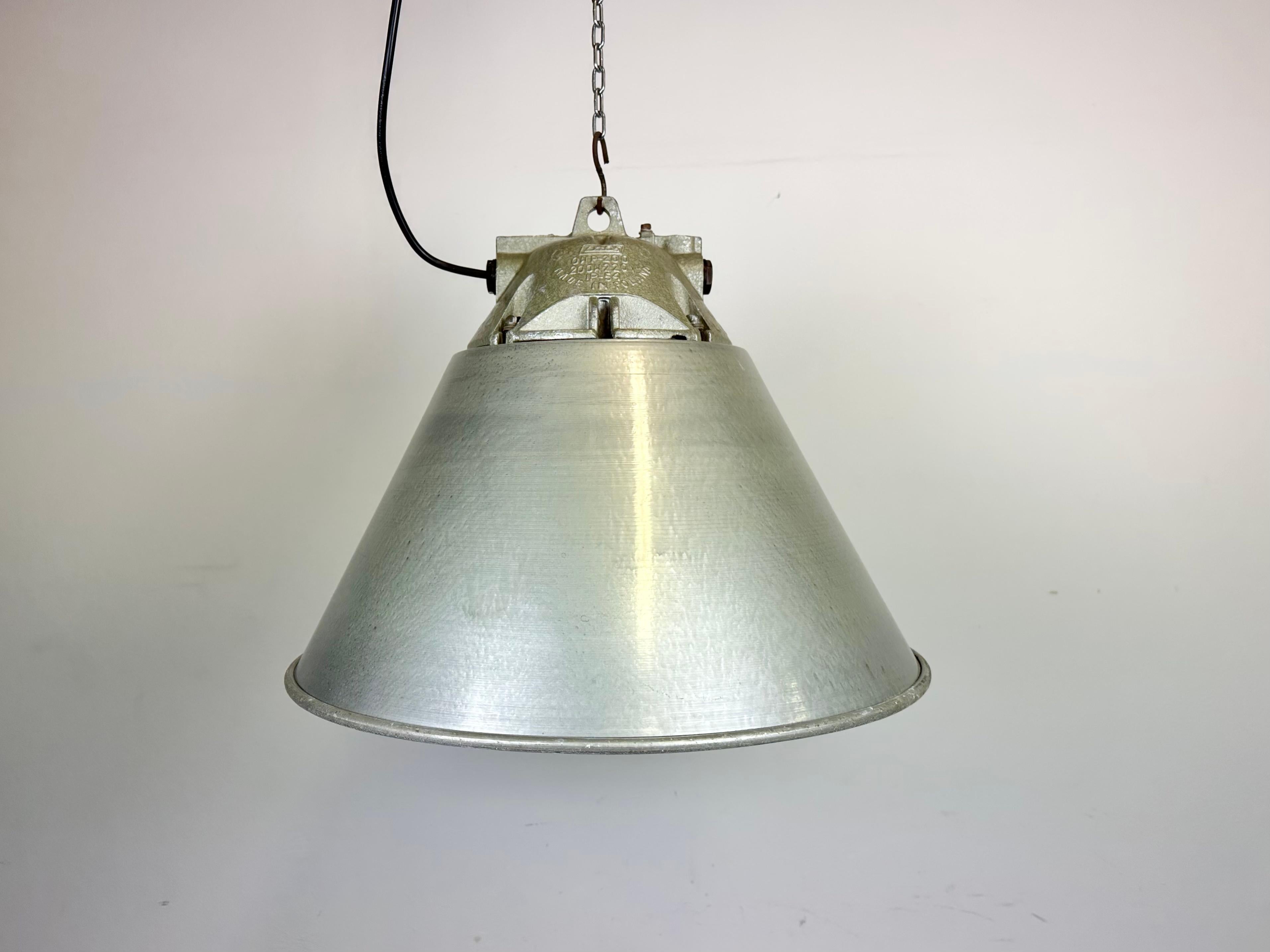 Industrial factory pendant light manufactured by Zaos in Poland during the 1970s. It features a cast aluminium body, an explosion-proof glass and grey hammerpaint aluminium shade with white interior.
The socket requires E27/ E26 lightbulbs. New