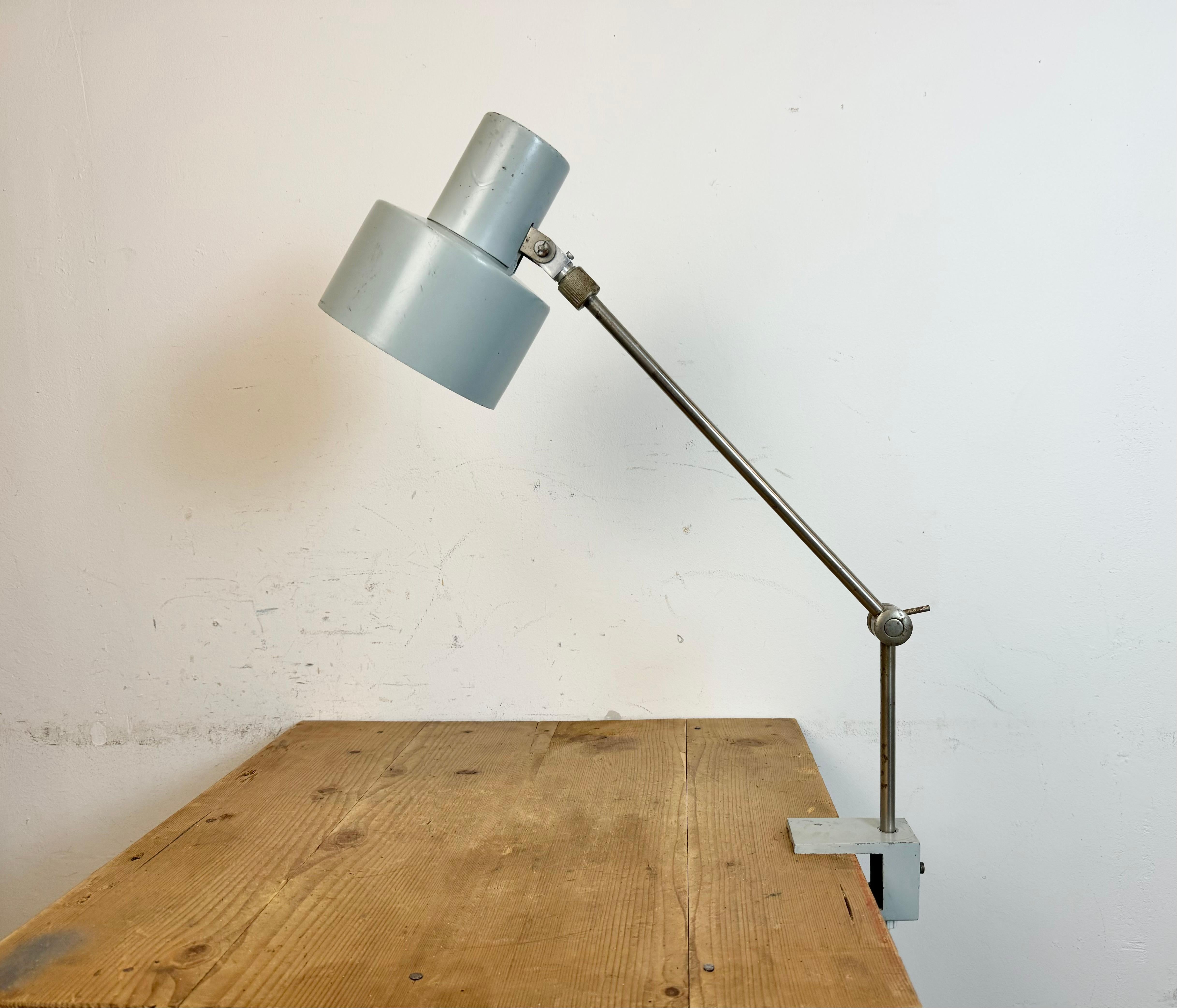 Lampe de bureau vintage grise fabriquée par Elektrosvit dans l'ancienne Tchécoslovaquie au cours des années 1970. Elle est dotée d'un abat-jour et d'une base en métal gris et d'un bras chromé avec deux articulations réglables.  Ampoules E27/ E26. Le