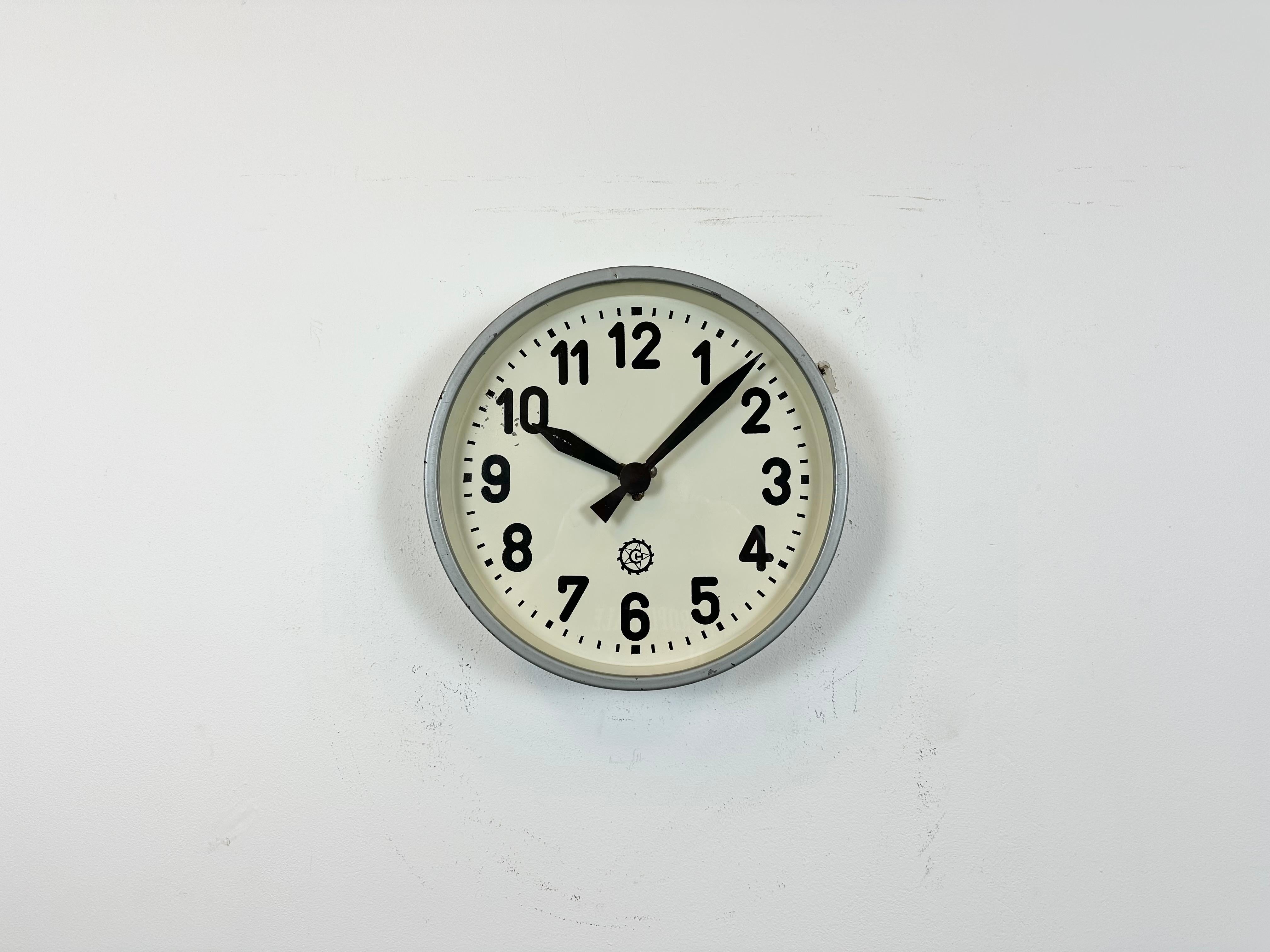 This factory wall clock wad produced by Chronotechna in former Czechoslovakia during the 1950s. It features a grey metal frame, iron dial, aluminum hands and clear glass cover. Former electrical slave clock has been converted into a battery-powered