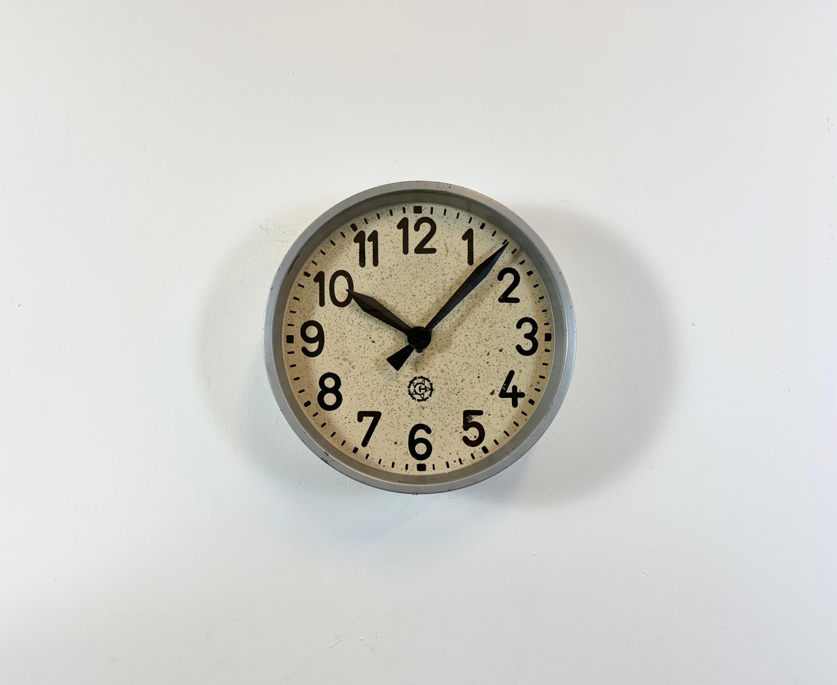 Cette horloge murale a été produite par Chronotechna dans l'ancienne Tchécoslovaquie au cours des années 1950. Elle se compose d'un cadre en métal gris, d'un cadran en fer, d'aiguilles en aluminium et d'un couvercle en verre transparent. La pièce a
