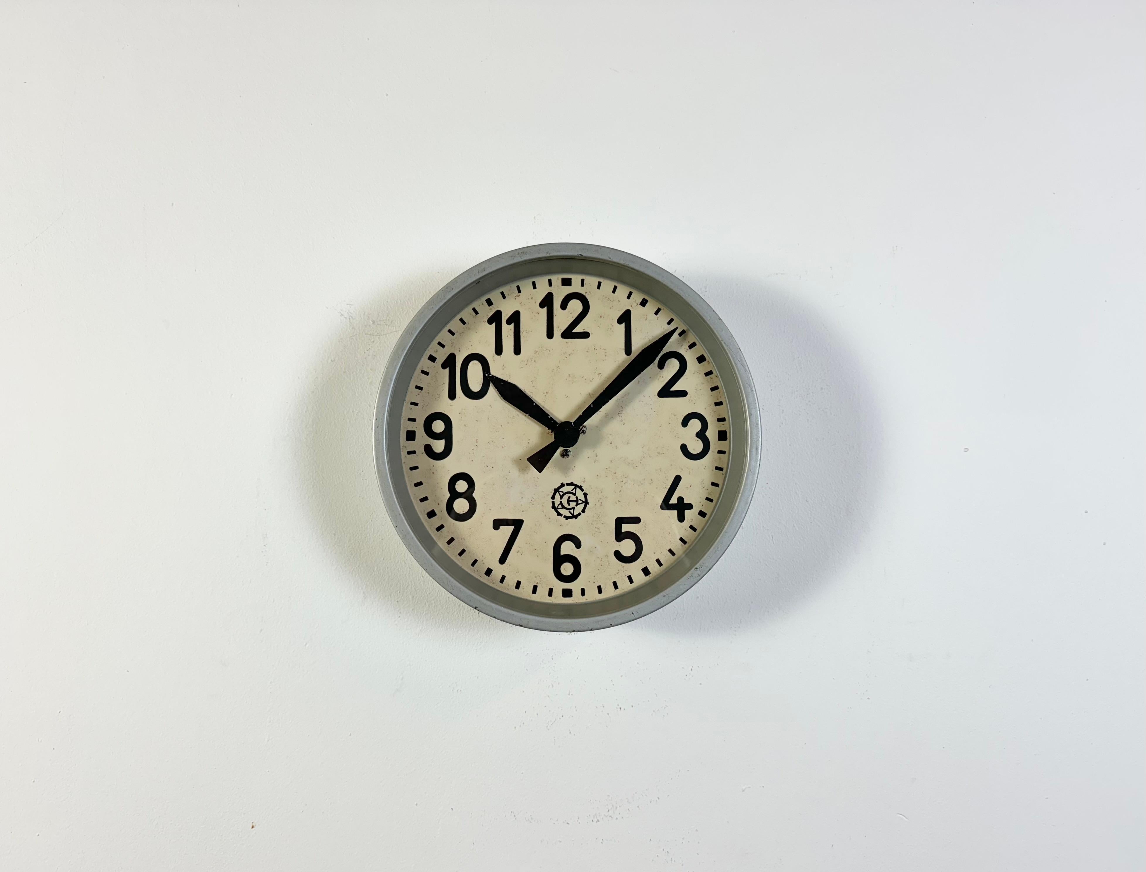 Cette horloge murale a été produite par Chronotechna dans l'ancienne Tchécoslovaquie au cours des années 1950. Elle se compose d'un cadre en métal gris, d'un cadran en fer, d'aiguilles en aluminium et d'un couvercle en verre transparent. La pièce a