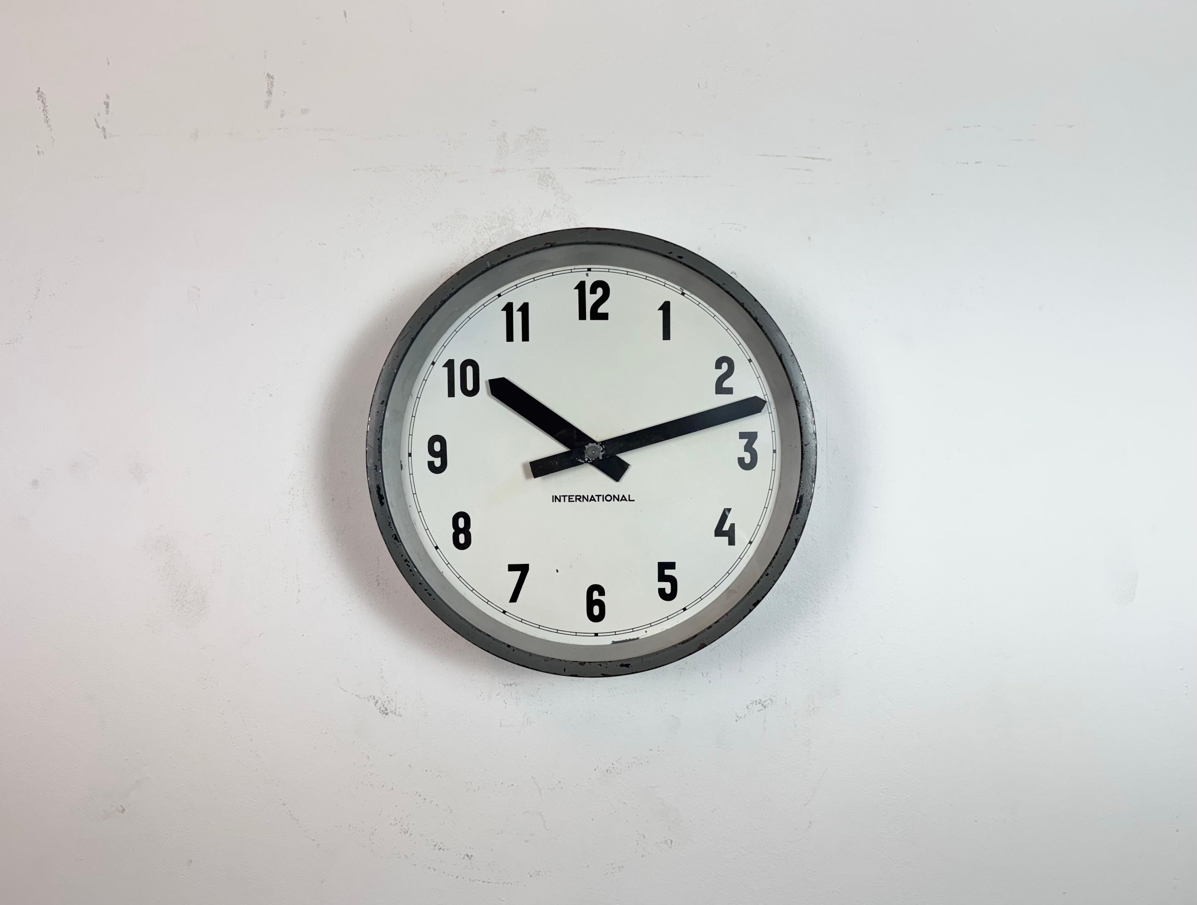 This wall clock was produced by International in Germany during the 1950s. It features a black metal frame, iron dial, aluminium hands and a clear glass cover. The piece has been converted into a battery-powered clockwork and requires only one