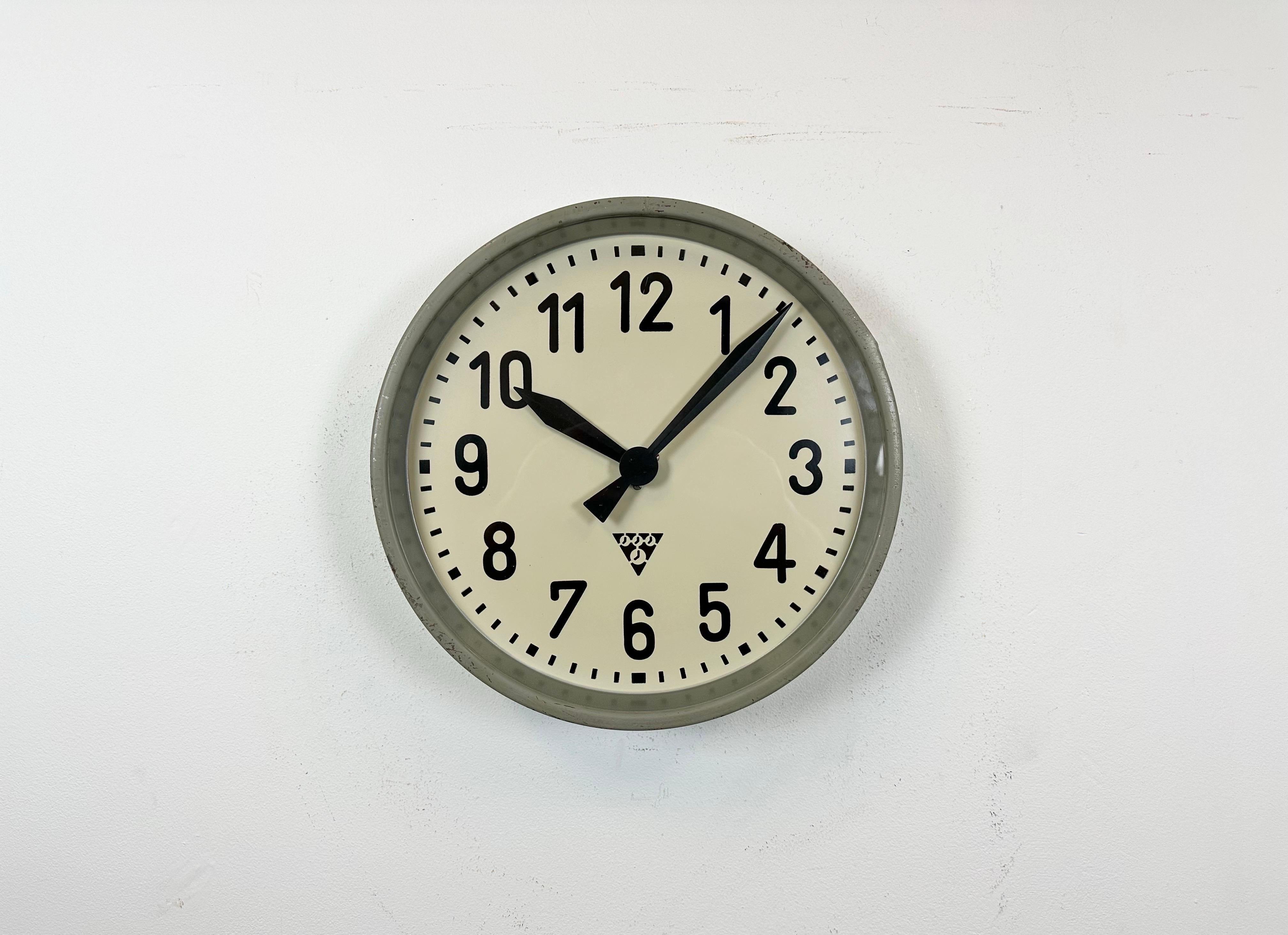 This wall clock was produced by Pragotron in former Czechoslovakia during the 1950s. It features a grey metal frame, an iron dial, an aluminium hands and a clear glass cover. Former factory slave clock has been converted into a battery-powered