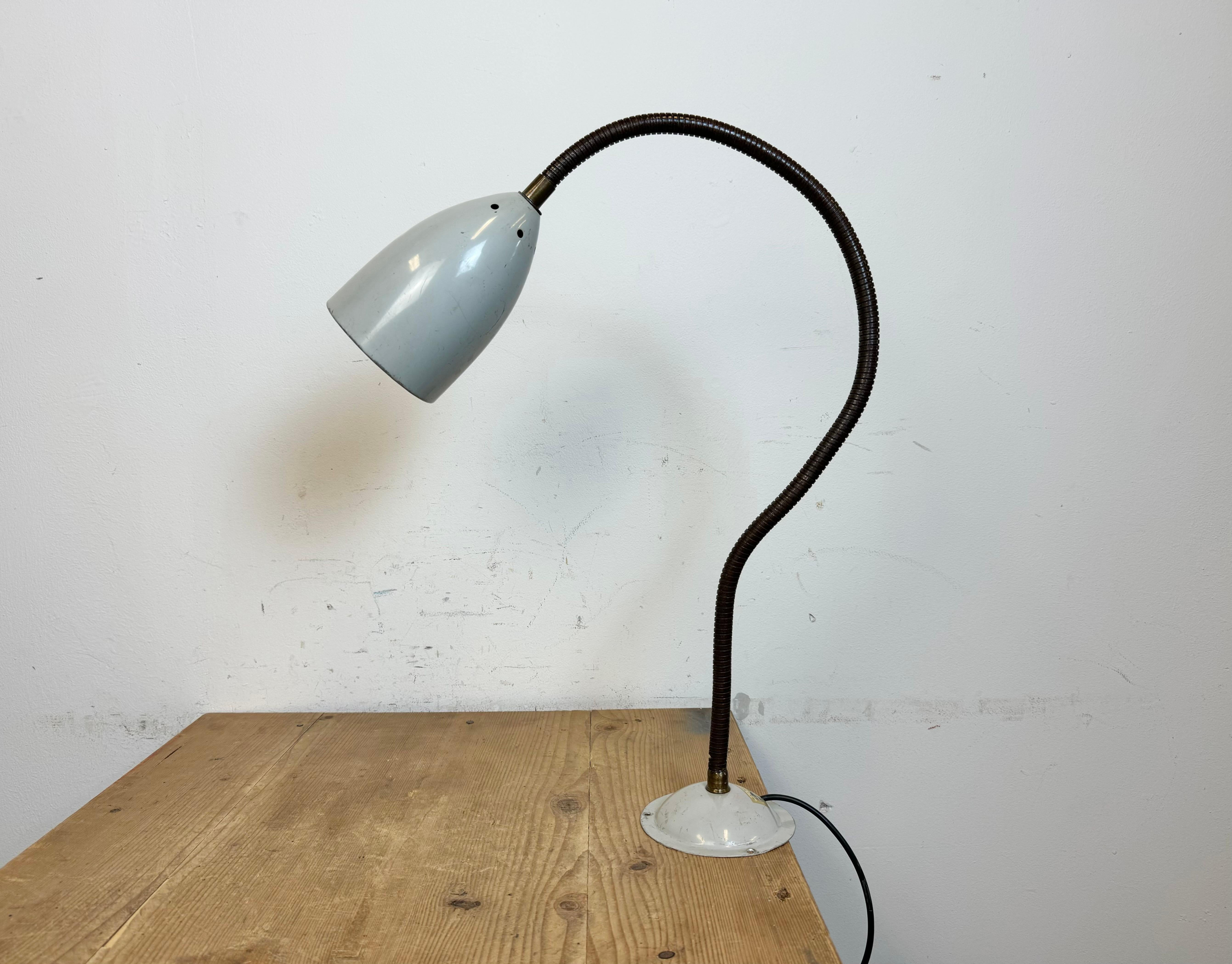 Lampe d'atelier industrielle réglable fabriquée par Philips en Belgique dans les années 1960. Elle se caractérise par une base et un abat-jour en métal gris et un col de cygne en fer. La douille d'origine nécessite des ampoules standard E27/E26.
Le
