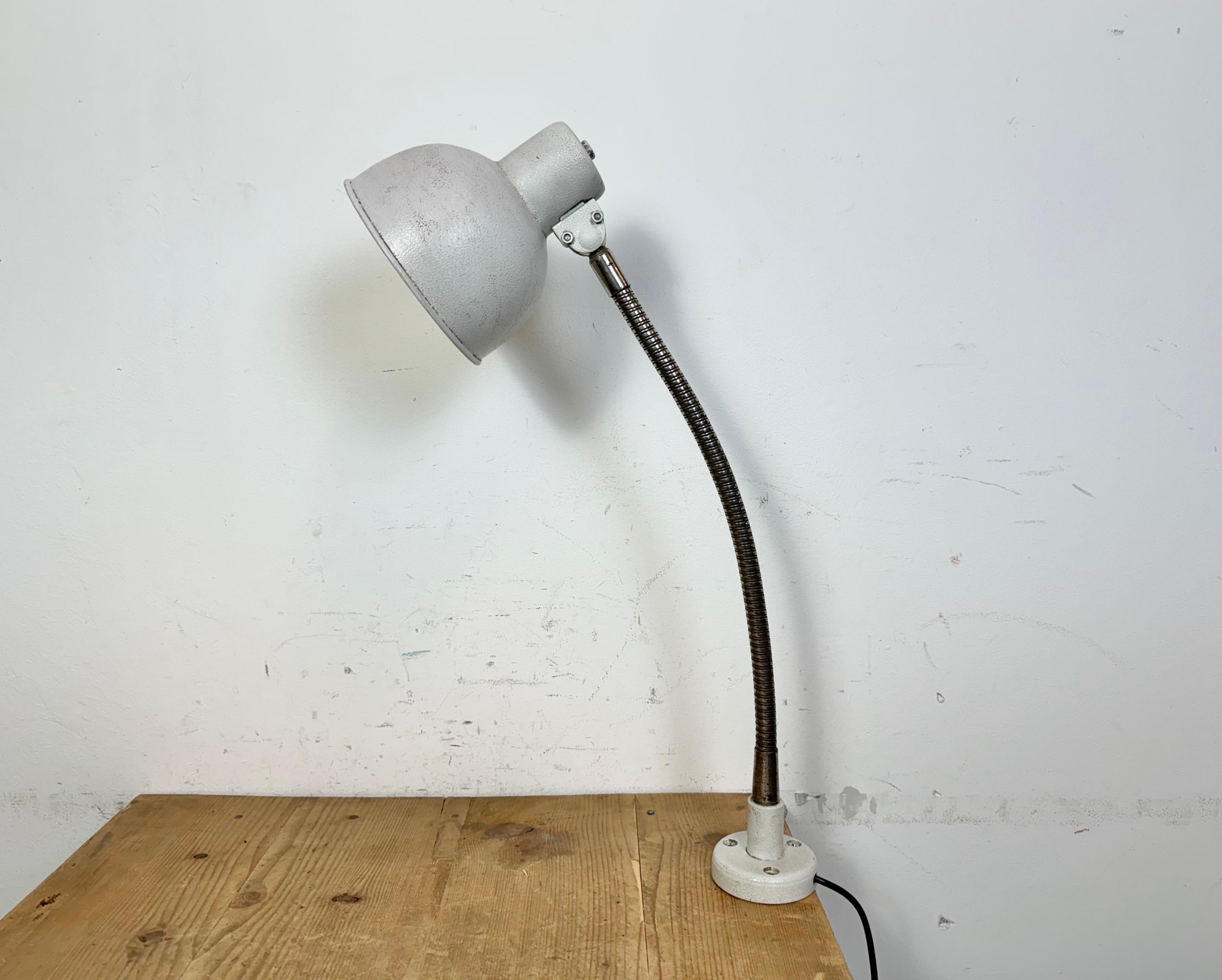 Industrial adjustable workshop table lamp made in former Czechoslovakia during the 1960s.It features a grey iron base and shade and a chrome plated gooseneck. The original socket requires standard E27/E26 lightbulbs. New wire.
The diameter of the