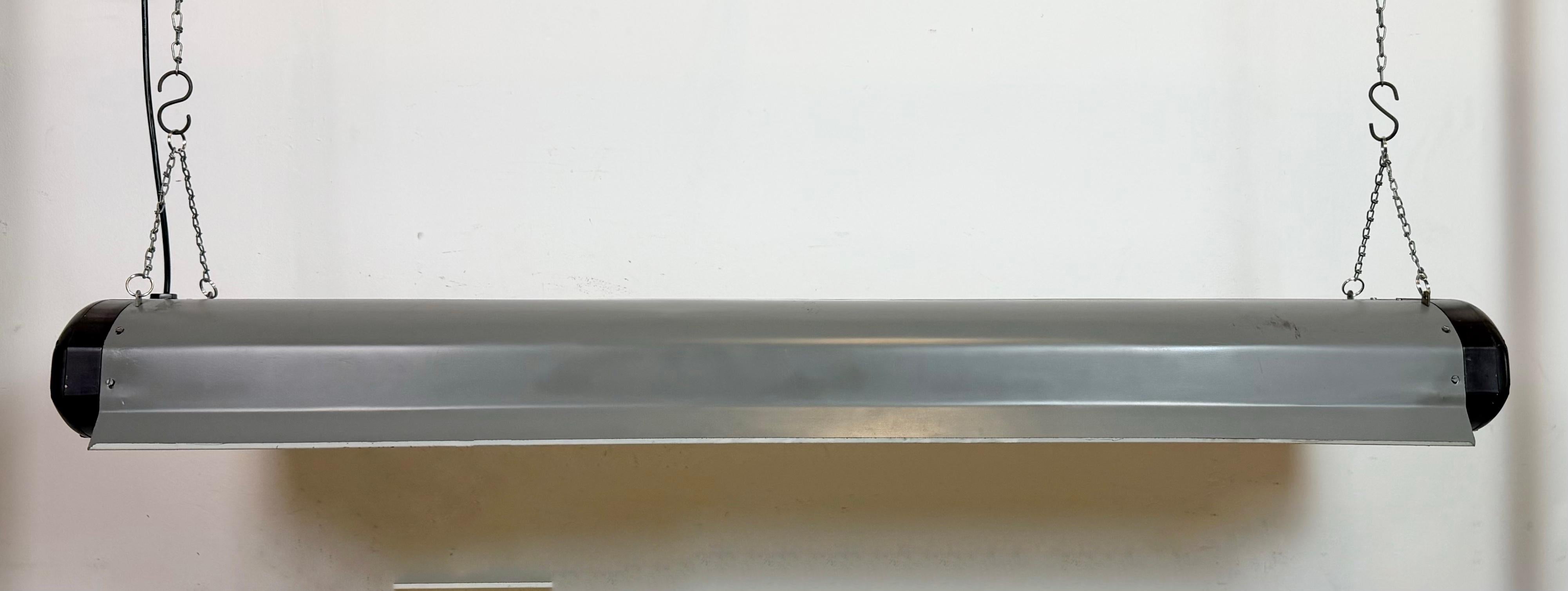 Esta lámpara de tubo industrial fue fabricada por Elektrosvit en la antigua Checoslovaquia durante la década de 1960. Tiene un cuerpo de baquelita y una pantalla de hierro gris. La luz se convierte en dos tubos de luz led T8 de 120 cm. El peso de la