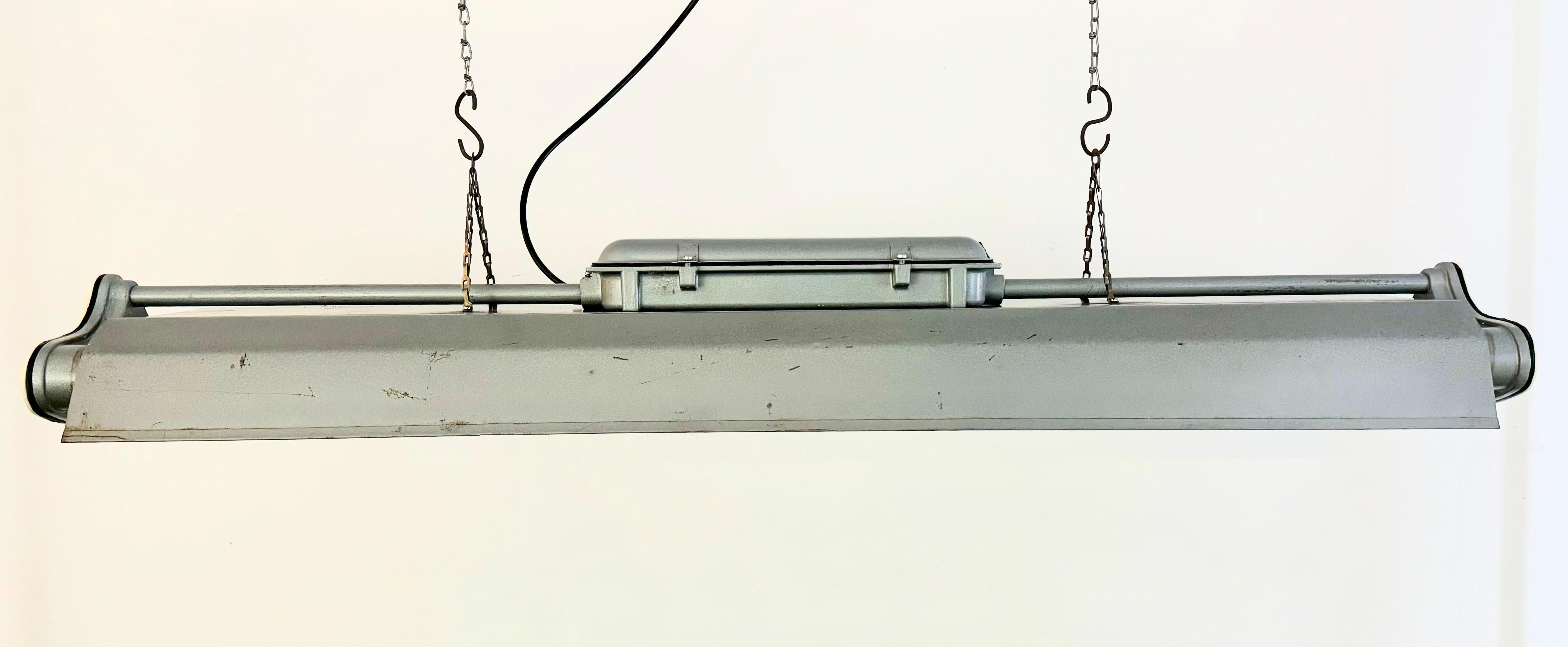 This industrial tube light was made by Polam Gdansk in Poland during the 1970s. It features an aluminium body and iron shade in grey hammerpaint color .The light is converted into three led T8, 120 cm light tubes. The weight of the lamp is 7 kg.