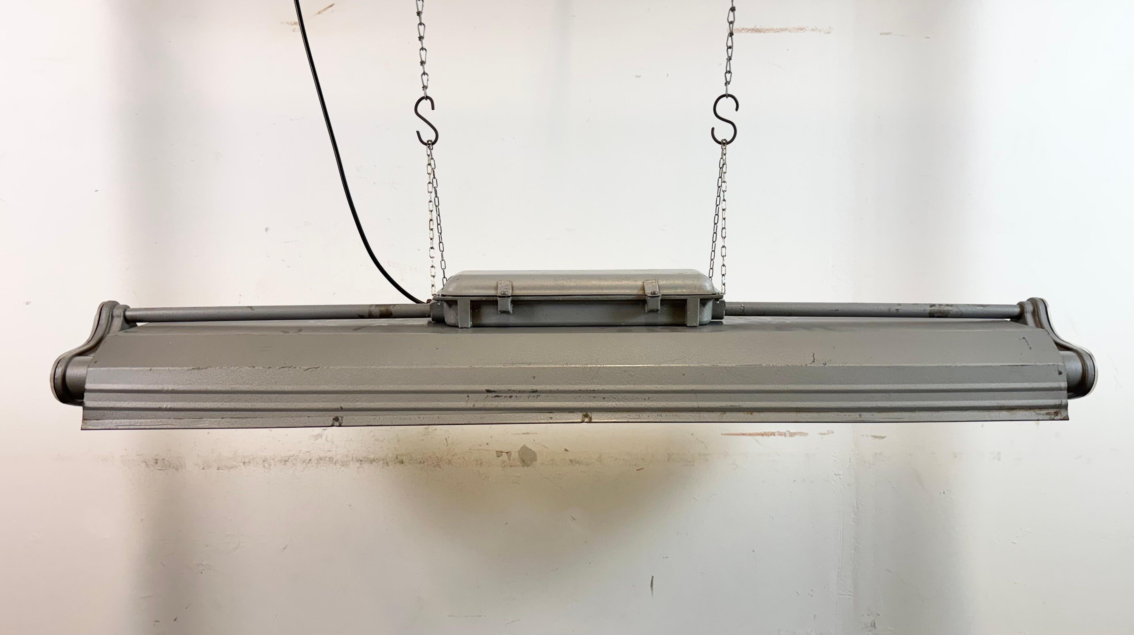 This industrial tube light was made by Polam Gdansk in Poland during the 1970s. It features an aluminium body and iron shade in grey hammerpaint color .The light is converted into three led T8, 120 cm light tubes. The weight of the lamp is 7 kg.