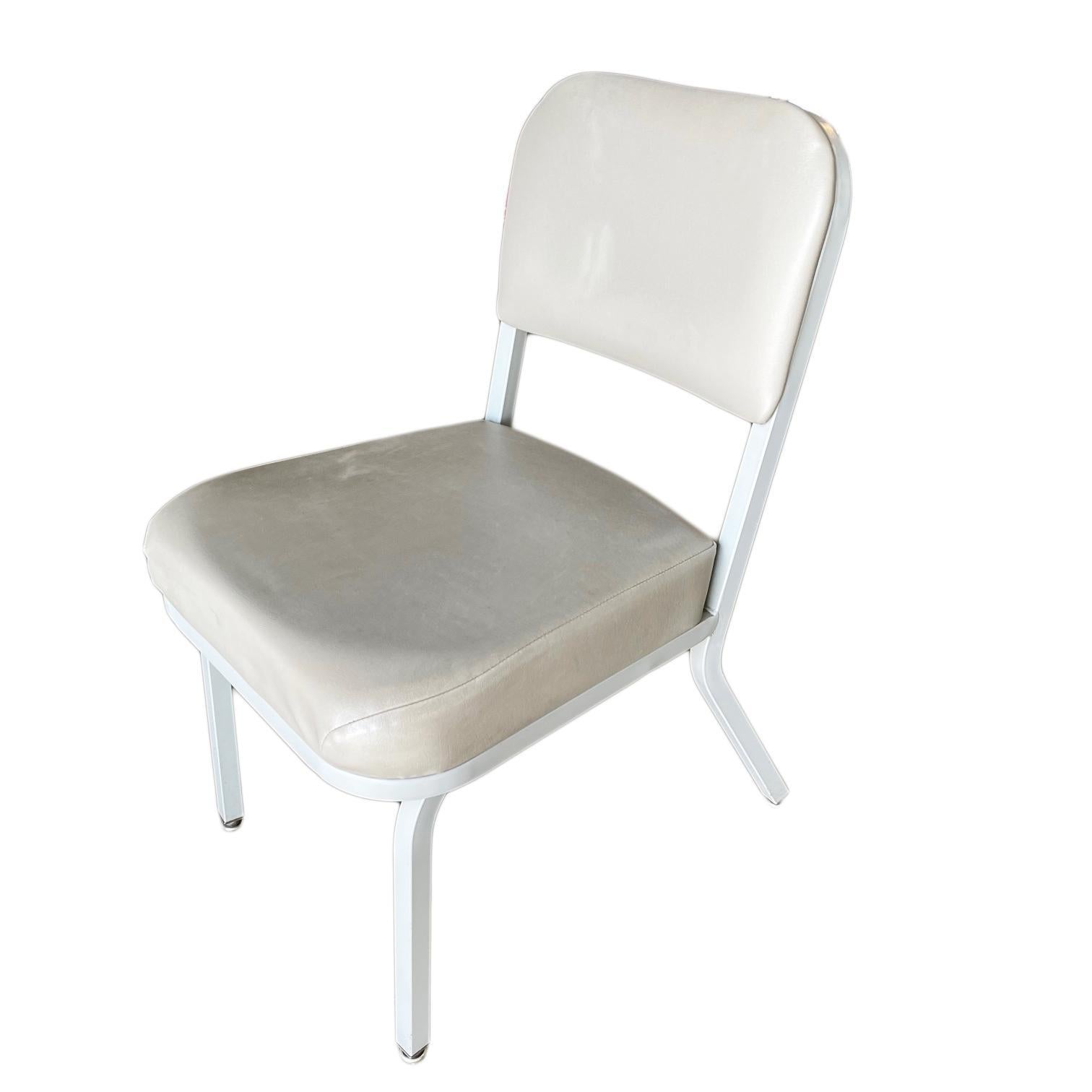 Set of two industrial tanker chairs with steel frames and vinyl seat covers, reminiscent of Steelcase.