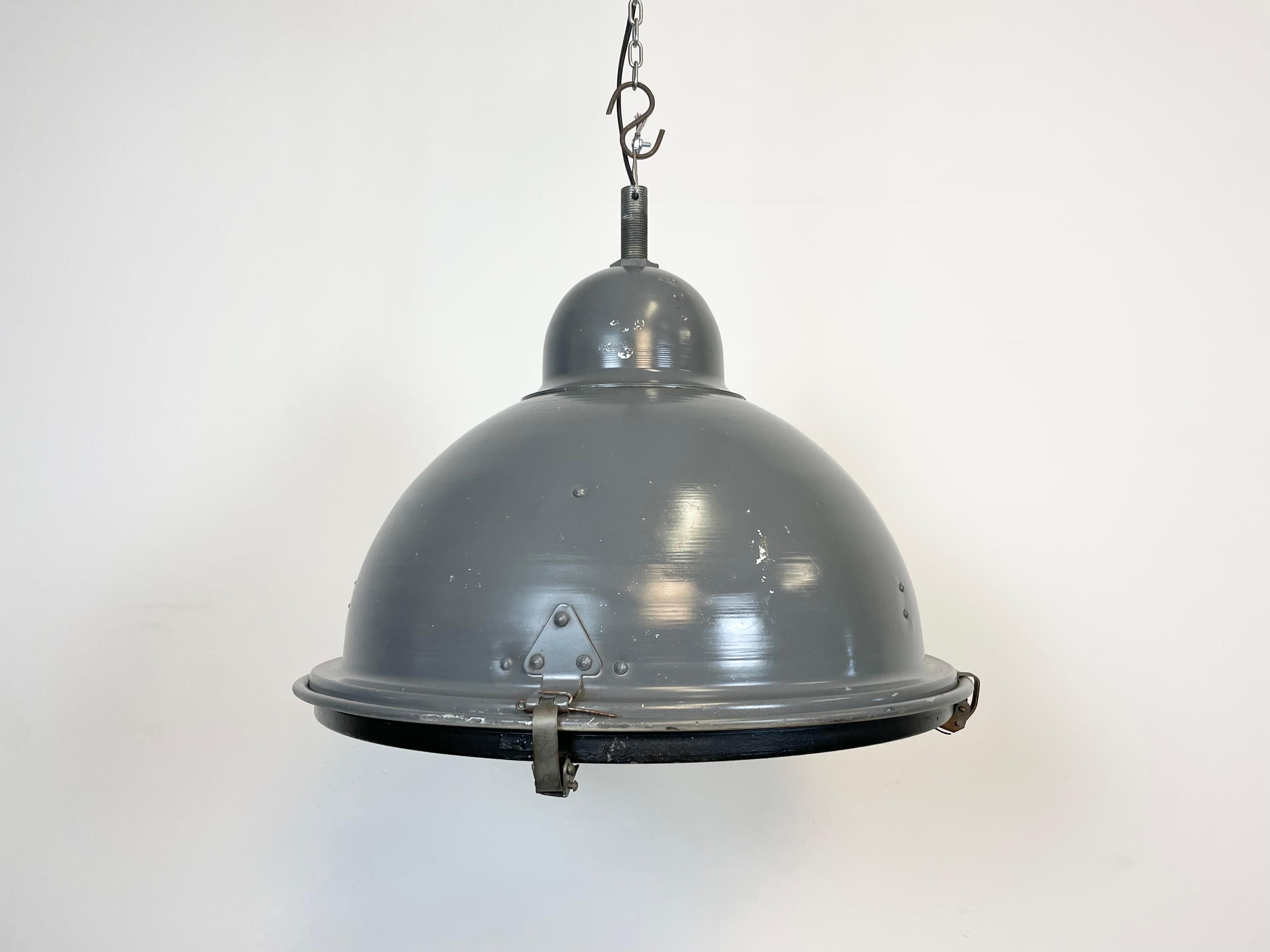 Vintage grey industrial factory aluminium pendant light made in Hungary during the 1970s. It features an aluminium body, an iron top and a clear glass cover. The socket requires E 27 light bulbs. The diameter of the shade is 46 cm. The weight of the