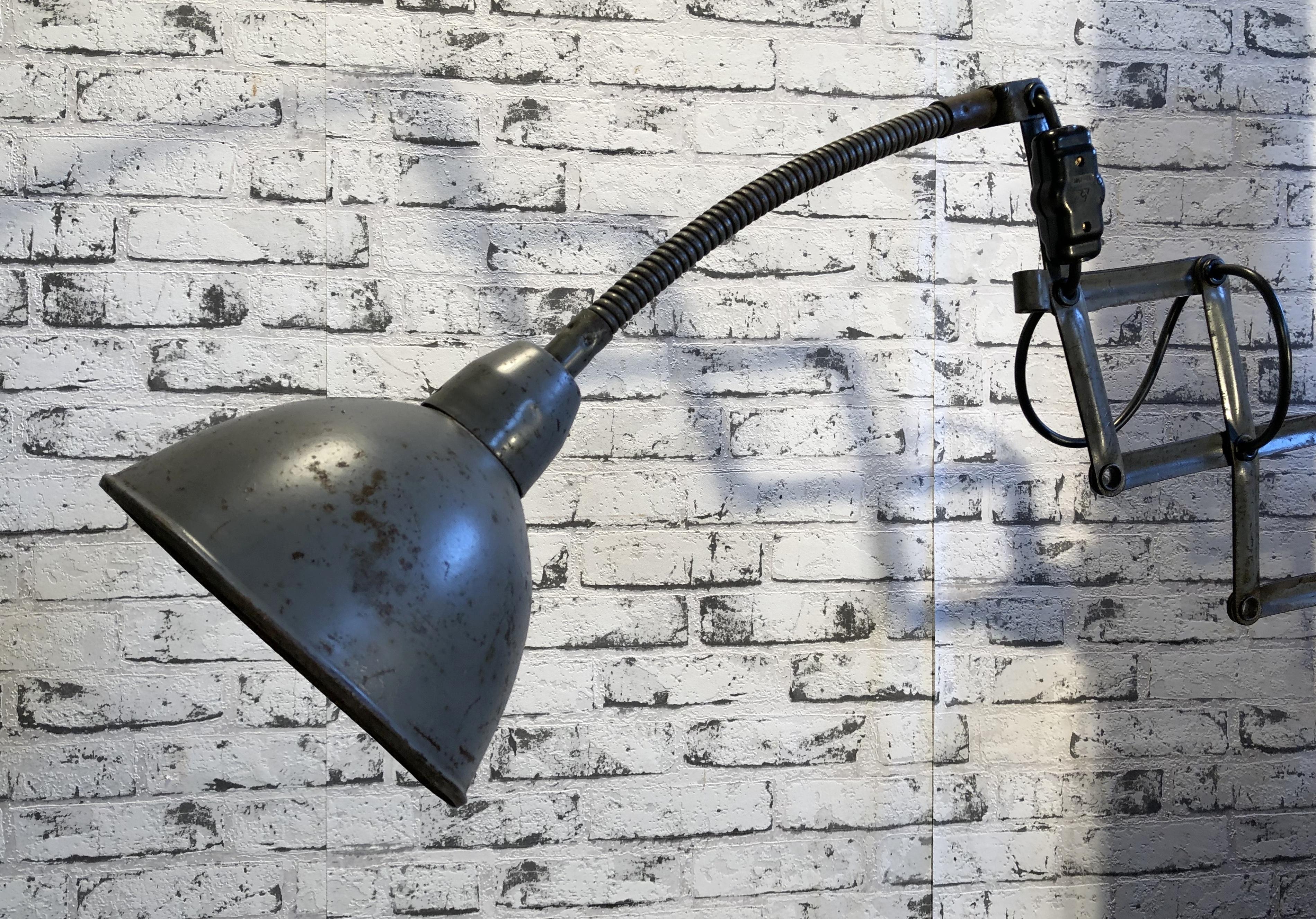 This vintage industrial scissor lamp was produced by Elektroinstala in former Czechoslovakia during the 1960s.Lamp has grey lampshade. Scissor arm is extendable and can be turned sideways. Socket for E 27 lightbulbs. Fully