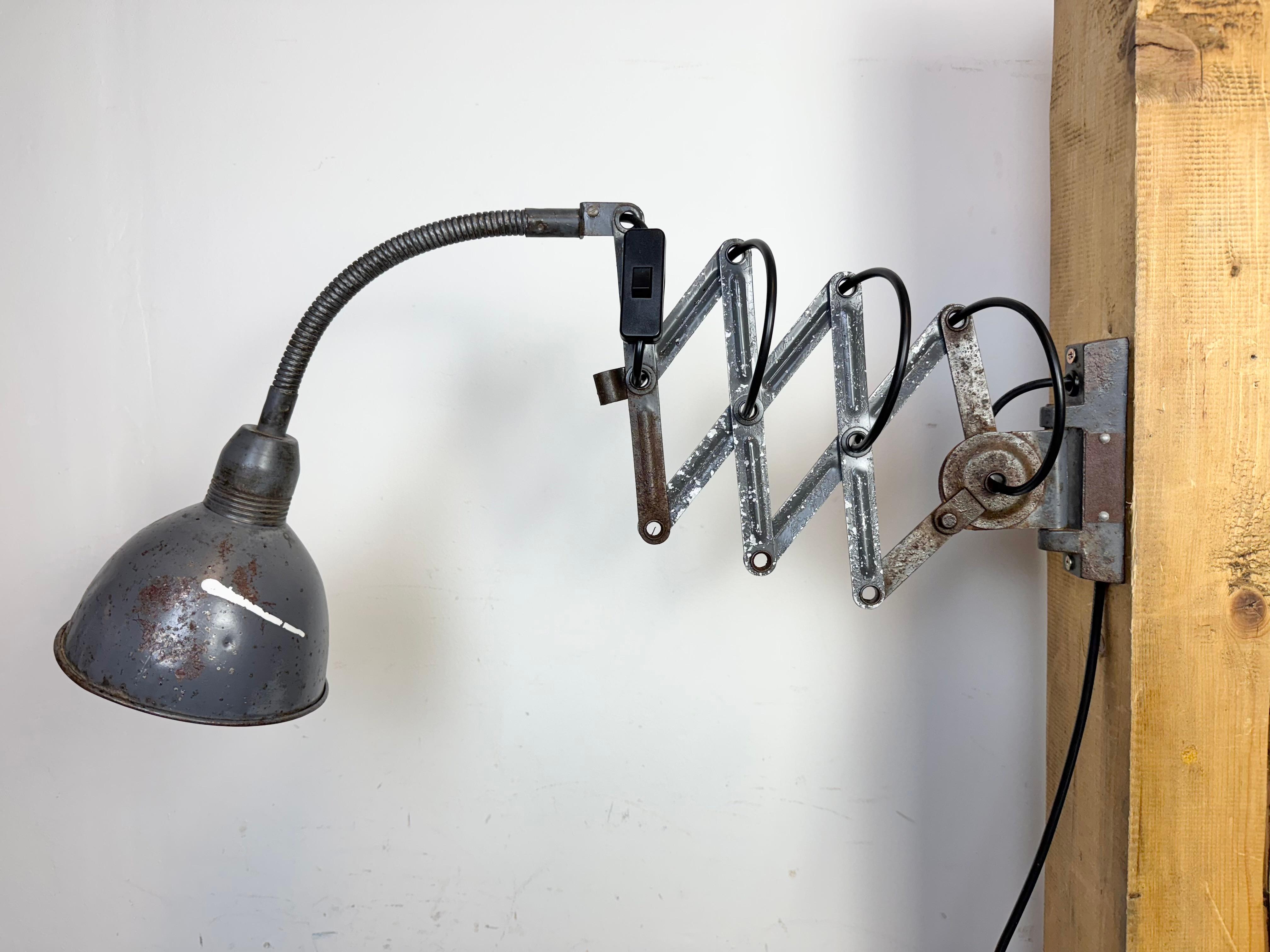 Questa applique a forbice vintage di colore grigio industriale è stata prodotta da Elektroinstala Dečín nell'ex Cecoslovacchia durante gli anni '60. Ha un paralume in metallo. Il braccio a forbice in ferro è estensibile e può essere girato