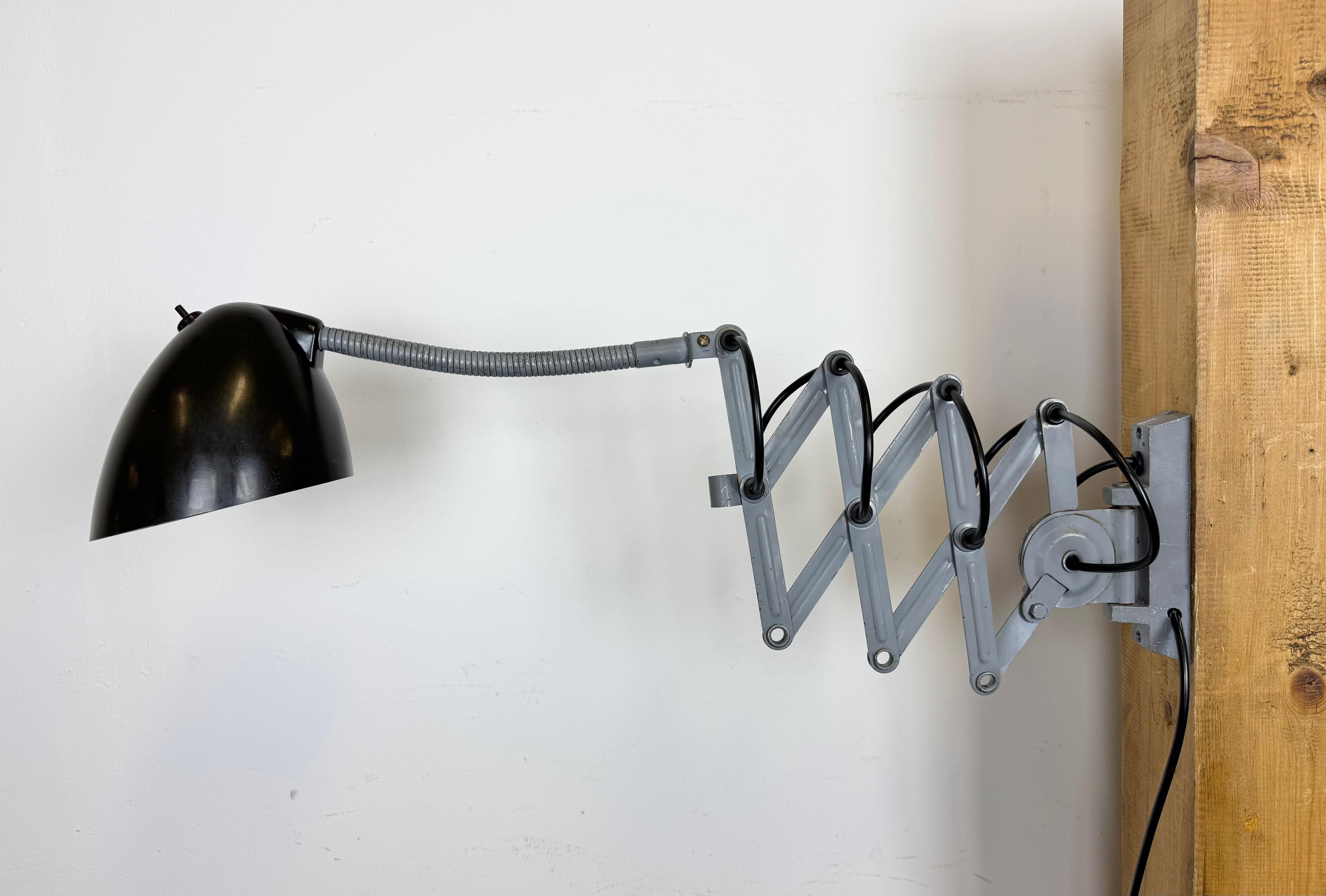 Diese verstellbare Schwanenhals-Wandleuchte im Vintage-Stil wurde in den 1960er Jahren von Elektroinstala in der ehemaligen Tschechoslowakei hergestellt. Die Lampe hat einen dunkelbraunen Bakelit-Schirm mit Schalter. Ein Grauguss-Scherenarm ist