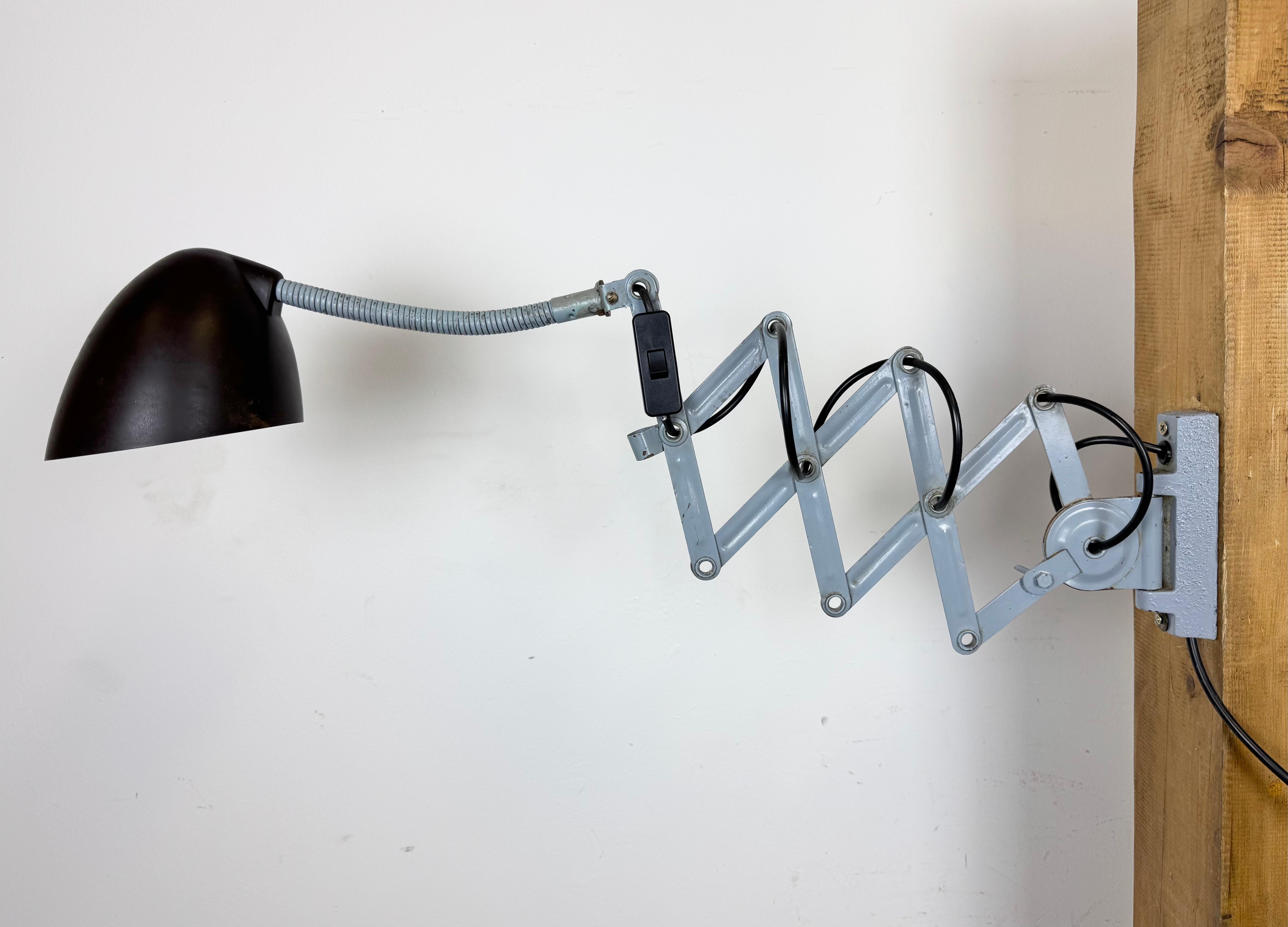 Este aplique industrial de cuello de cisne regulable vintage fue fabricado por Elektroinstala en la antigua Checoslovaquia durante la década de 1960. El brazo de tijera de hierro gris claro es extensible y puede girarse lateralmente. El casquillo