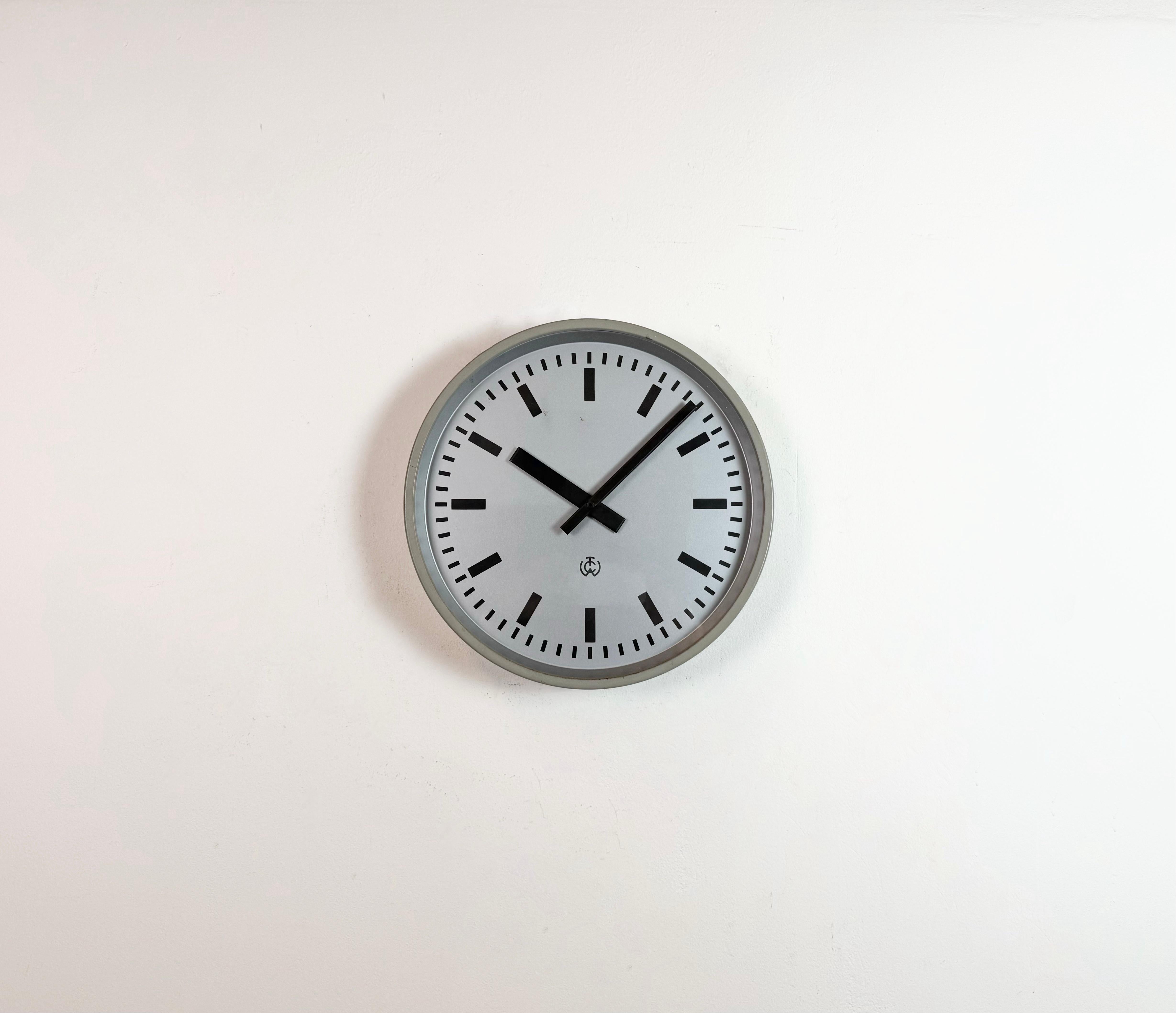 TCW post office wall clock was made in Netherlands during the 1960s. It features a grey iron frame, a metal dial, an aluminium hands and clear glass cover. The piece has been converted into a battery-powered clockwork and requires only one AA
