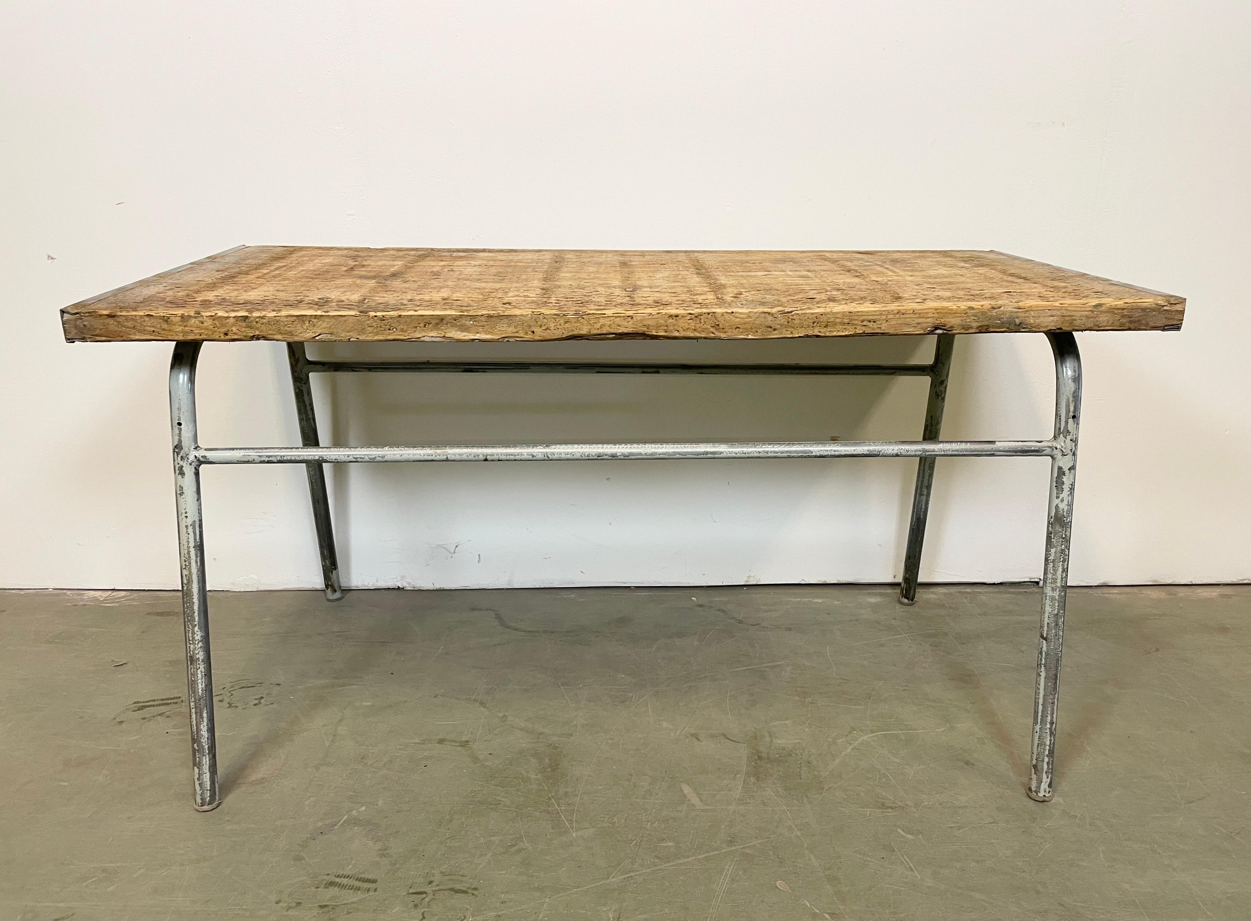 Grey Industrial table made during the 1960s. It features a iron construction and a solid wooden plate. The weight of the table is 23 kg.
