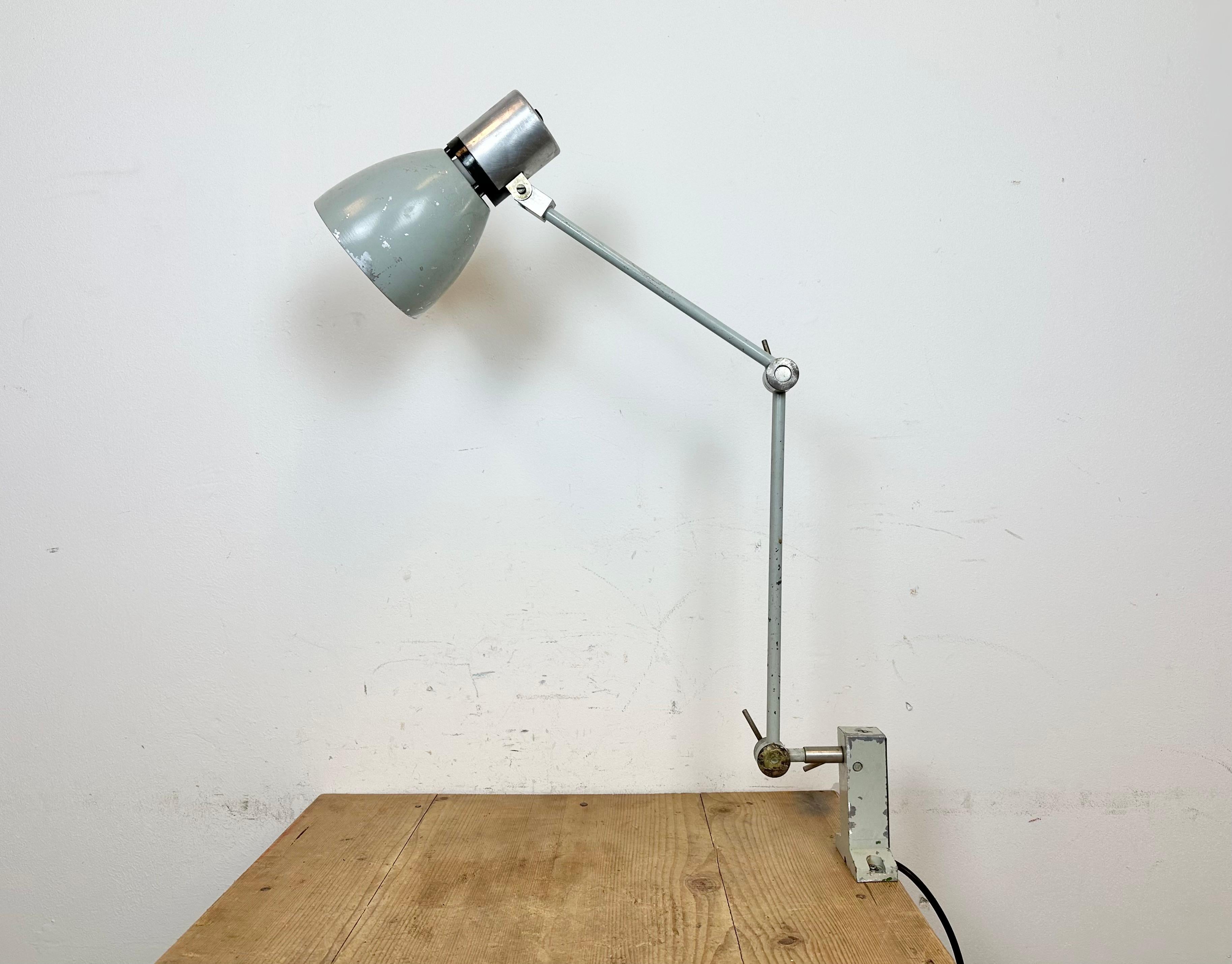 Industrial table lamp made by Elektrosvit in former Czechoslovakia during the 1970s. It features an iron base, an iron arm with three adjustable joints and aluminium shade with original switch on the top. The socket requires standard E 27 / E26