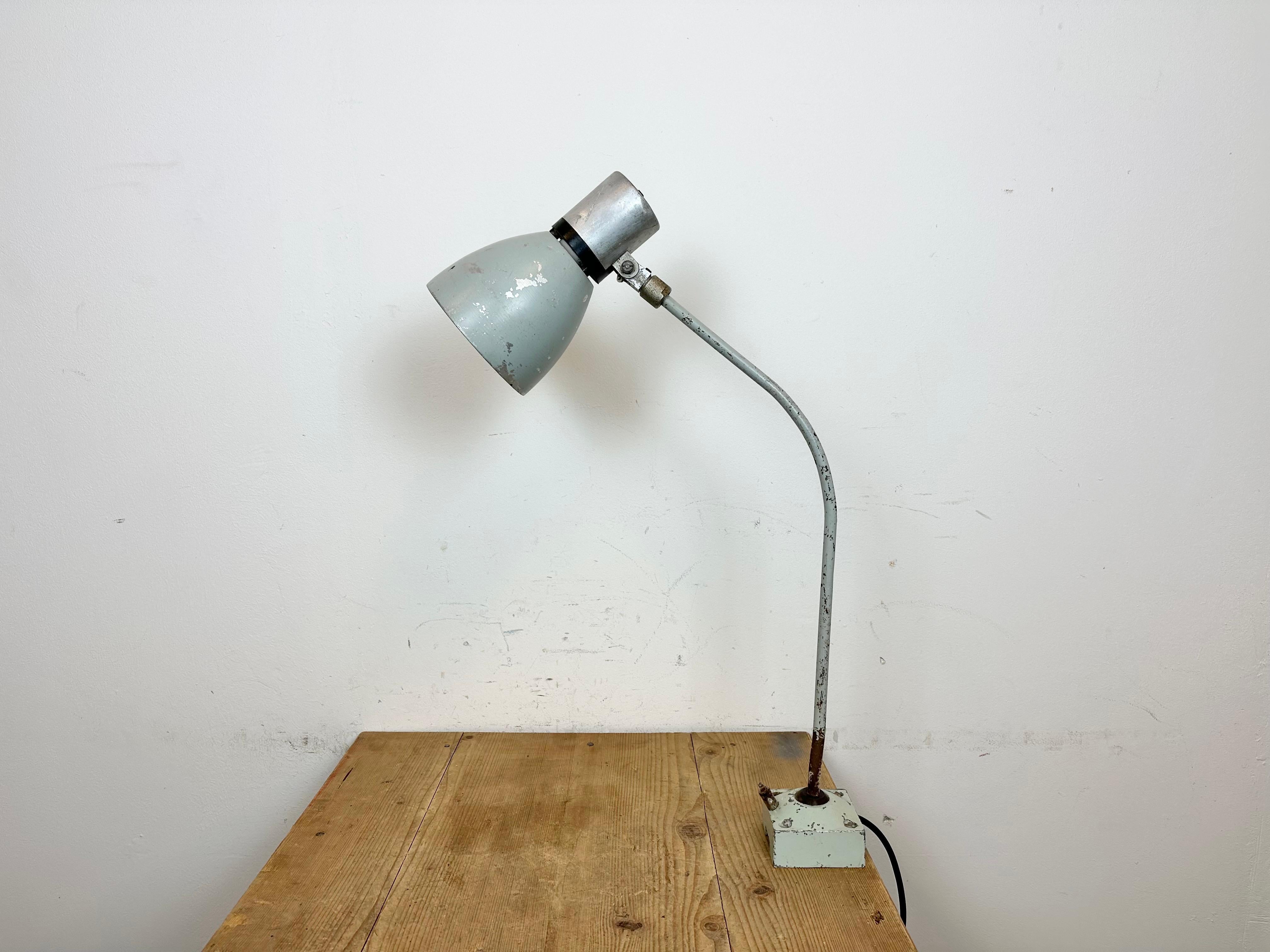 Industrial workshop table lamp made by Elektrosvit in former Czechoslovakia during the 1970s. It features an iron base and arm and aluminium shade with original switch on the top. The socket requires standard E 27 / E26 lightbulbs. New wiring. The