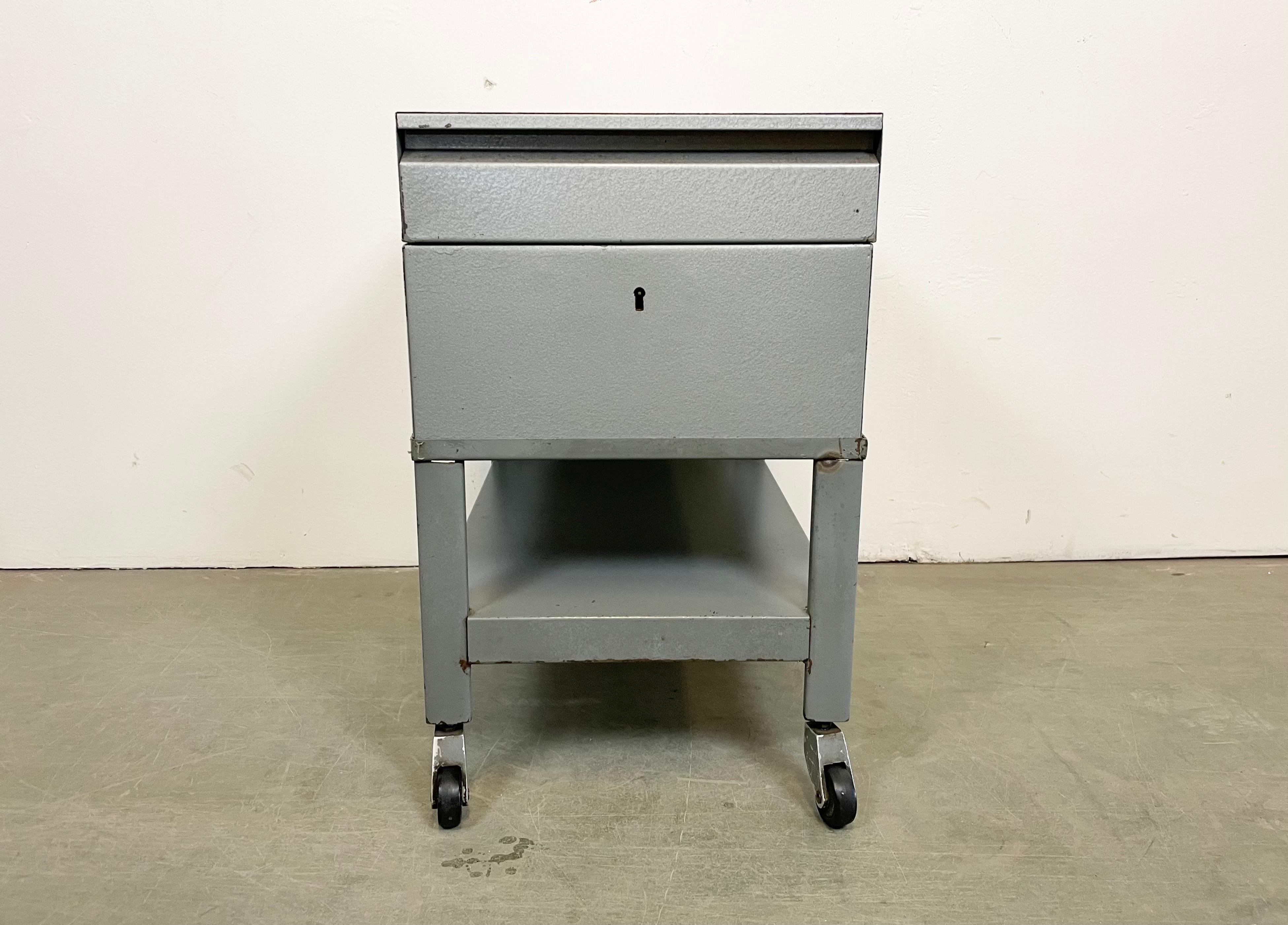 Vintage industrial box on wheels, ( former filling cabinet ) ,was made by Obzor Košice in Slovakian part of former Czechoslovakia during the 1960s Now can be serves as a cart bar or nightstand. It features a grey hammerpaint metal box and grey iron