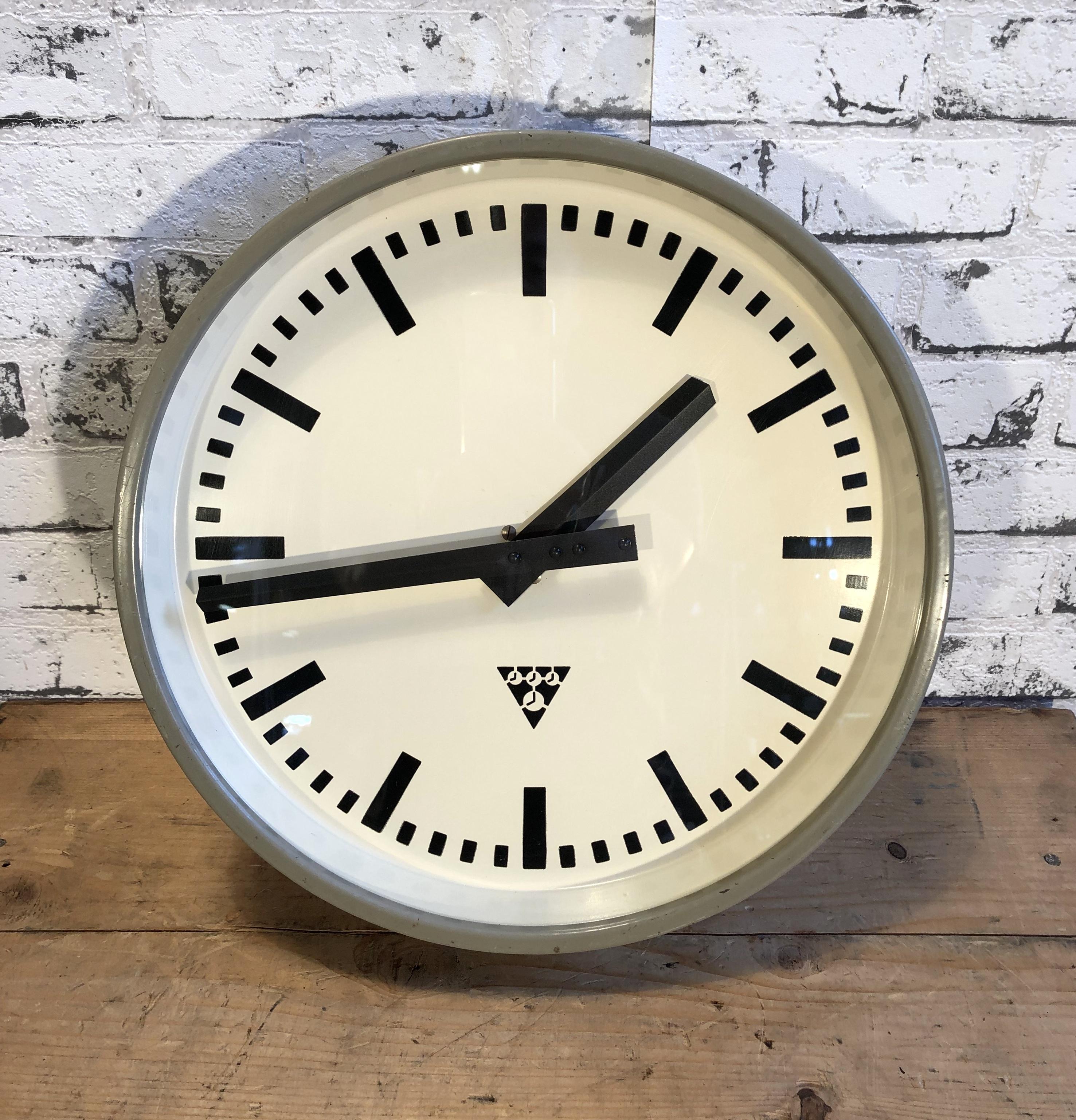 Pragotron wall clock made in former Czechoslovakia during the 1960s. It Features a grey metal frame, iron dial and clear glass cover. The piece has been converted into a battery-powered clockwork and requires only one AA-battery. Measure: Diameter