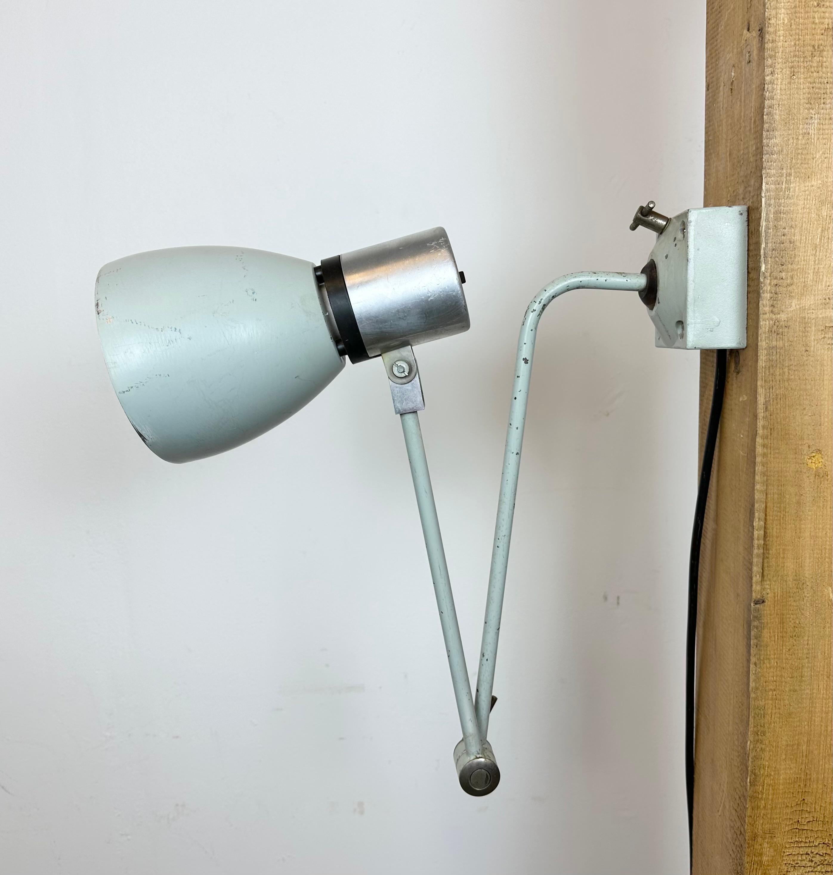 Industrial wall light made by Elektrosvit in former Czechoslovakia during the 1970s. It features an iron base, an iron arm with two  adjustable joints and aluminium shade with original switch on the top. The socket requires standard E 27 / E26