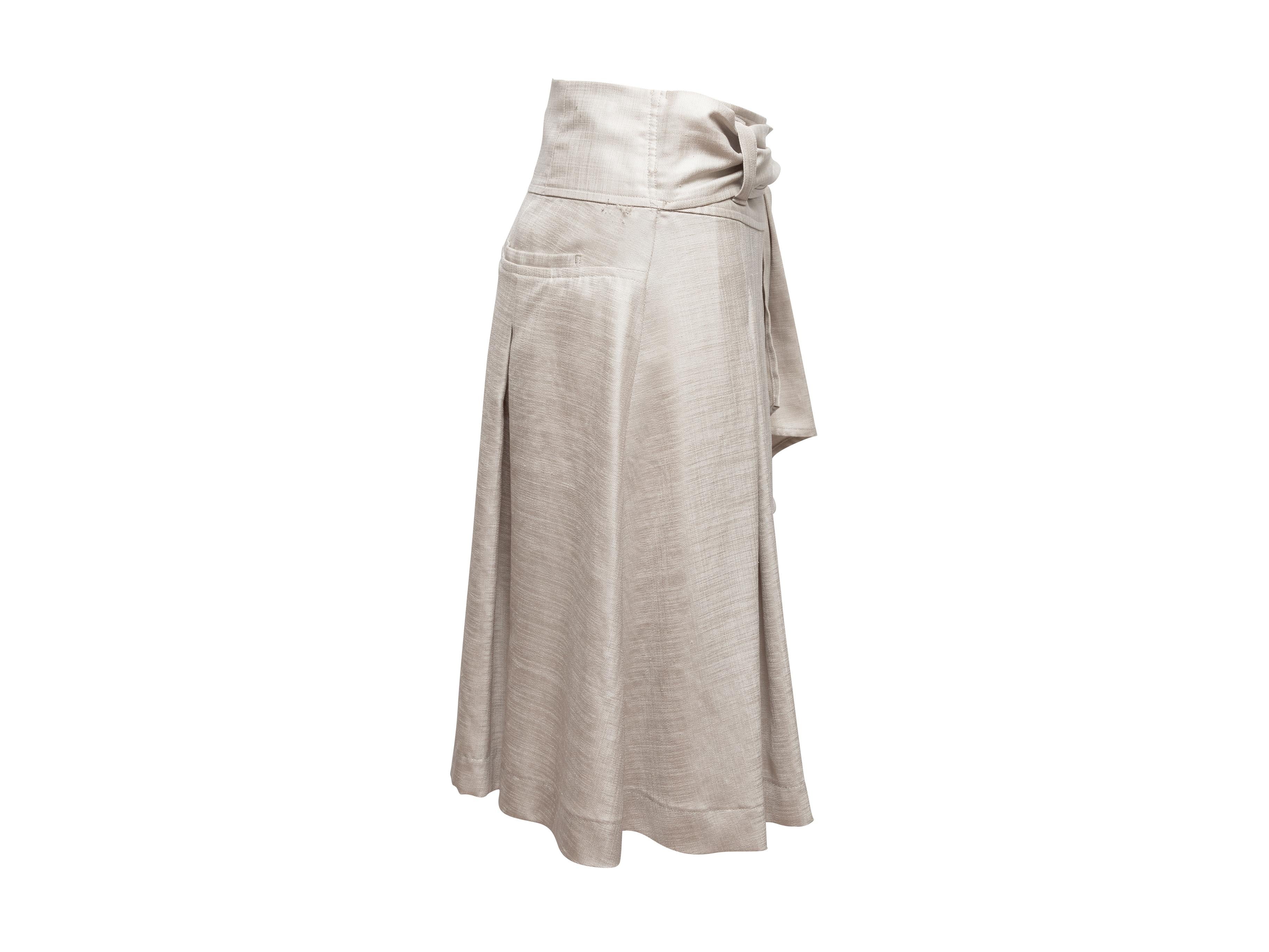 Product Details: Grey linen pleated skirt by Issey Miyake. Dual back packets. Sash tie closure at waist. 27