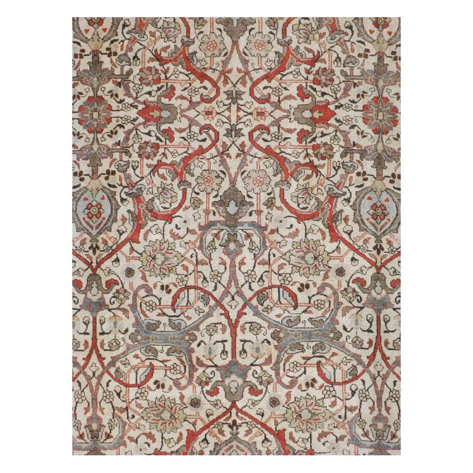 Ein antiker, zimmergroßer persischer Täbriz-Teppich aus dem frühen 20. Jahrhundert mit einem kreuzförmigen Arabeskenmuster in Grau-, Elfenbein- und Rottönen.

Maße: 9' 4