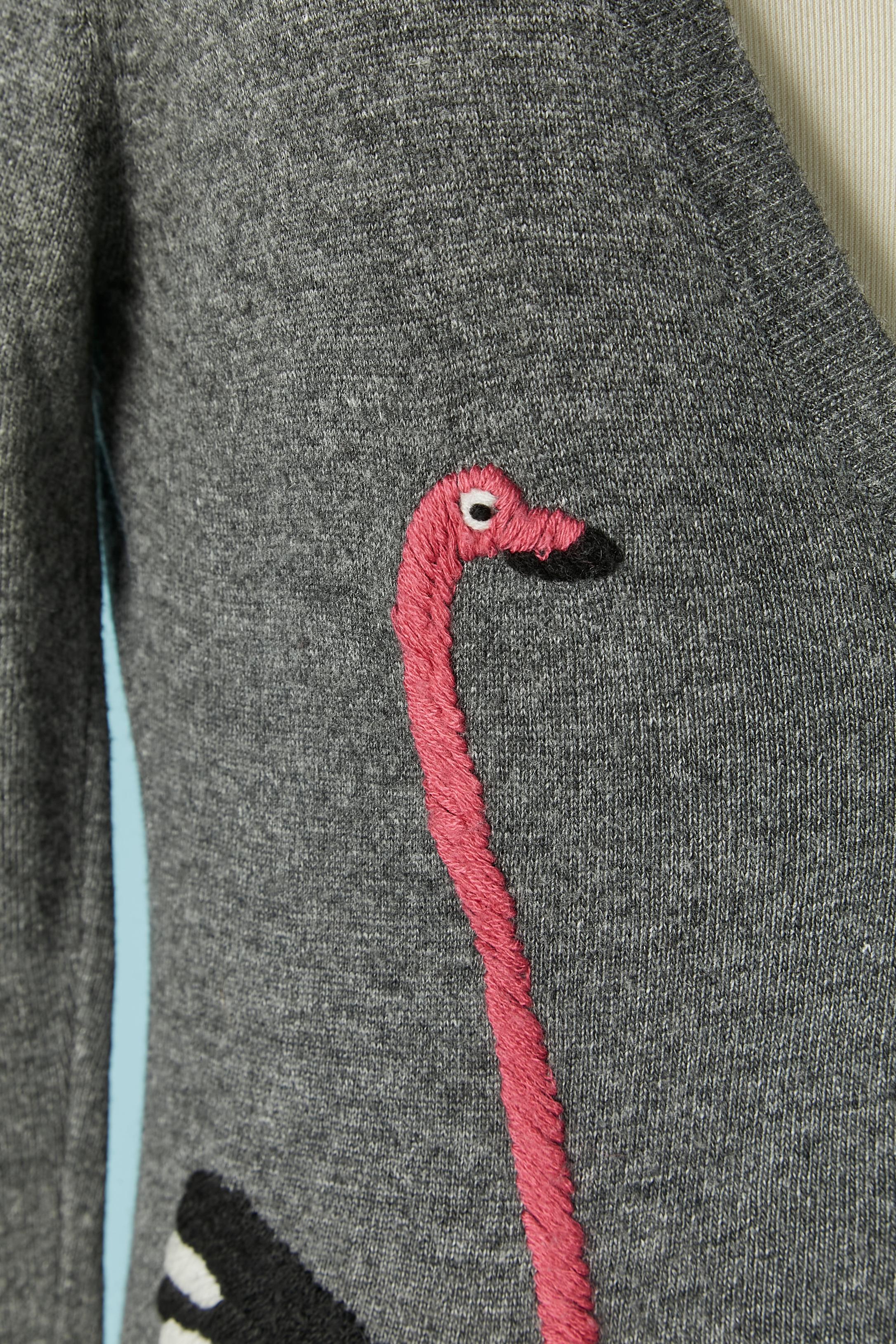 Grey knit cardigan with wool thread ostrich embroideries on. Knit composition: 40% rayon, 30% wool, 20% angora, 10% nylon. Button and buttonhole closure on the middle front . 
SIZE 38 (Fr) 