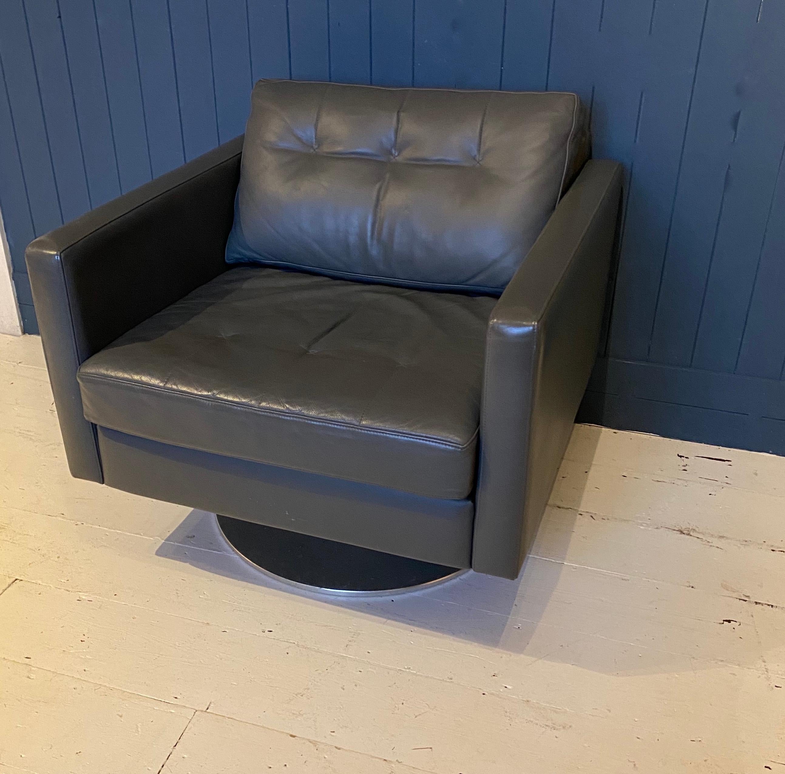 A high-end leather armchair by Davison Highley. We have a pair available. Made using the finest leather and British design. Having a deep comfortable seat, slender arms and standing on a heavy circular steel base. Seat height is 45cm. A contemporary