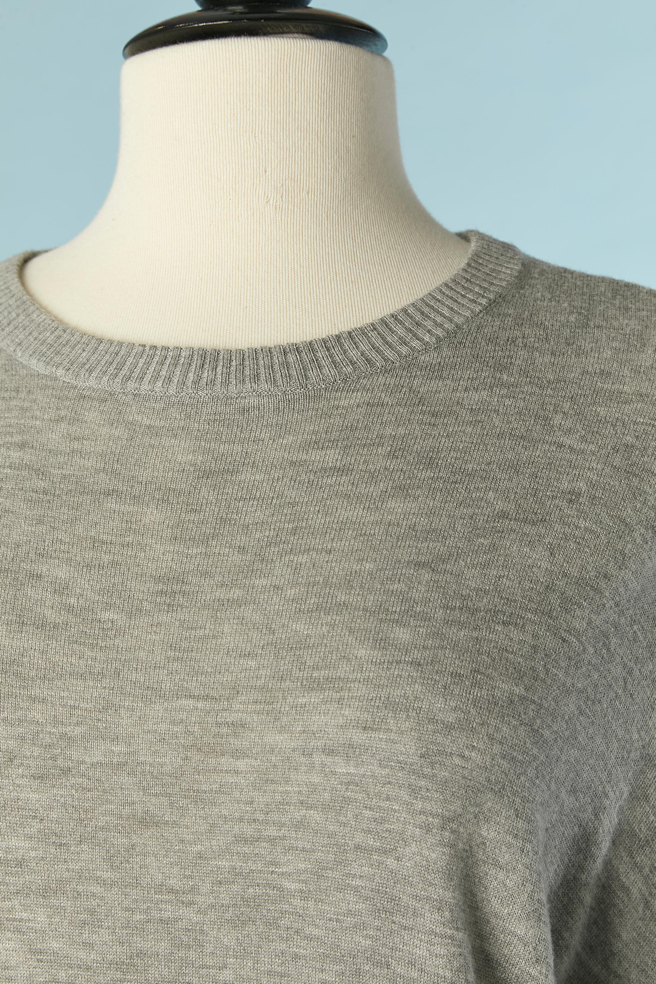 Maglione grigio oversize con fiocco in maglia nera al centro della schiena. 
Composizione della maglia: 40% nylon, 30% lana, 30% rayon. 
Marchio in metallo dorato sul lato anteriore inferiore 
Oversize/ L.A. 