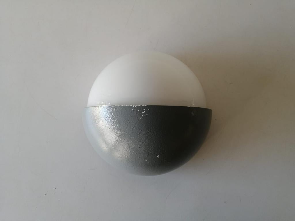 Grey metal and white round glass single sconce by BEGA, 1960s, Germany

Lamps are in very good vintage condition.
Wear consistent with age and use

These lamp works with fluorescent standard light bulb. 
Wired and suitable to use in all