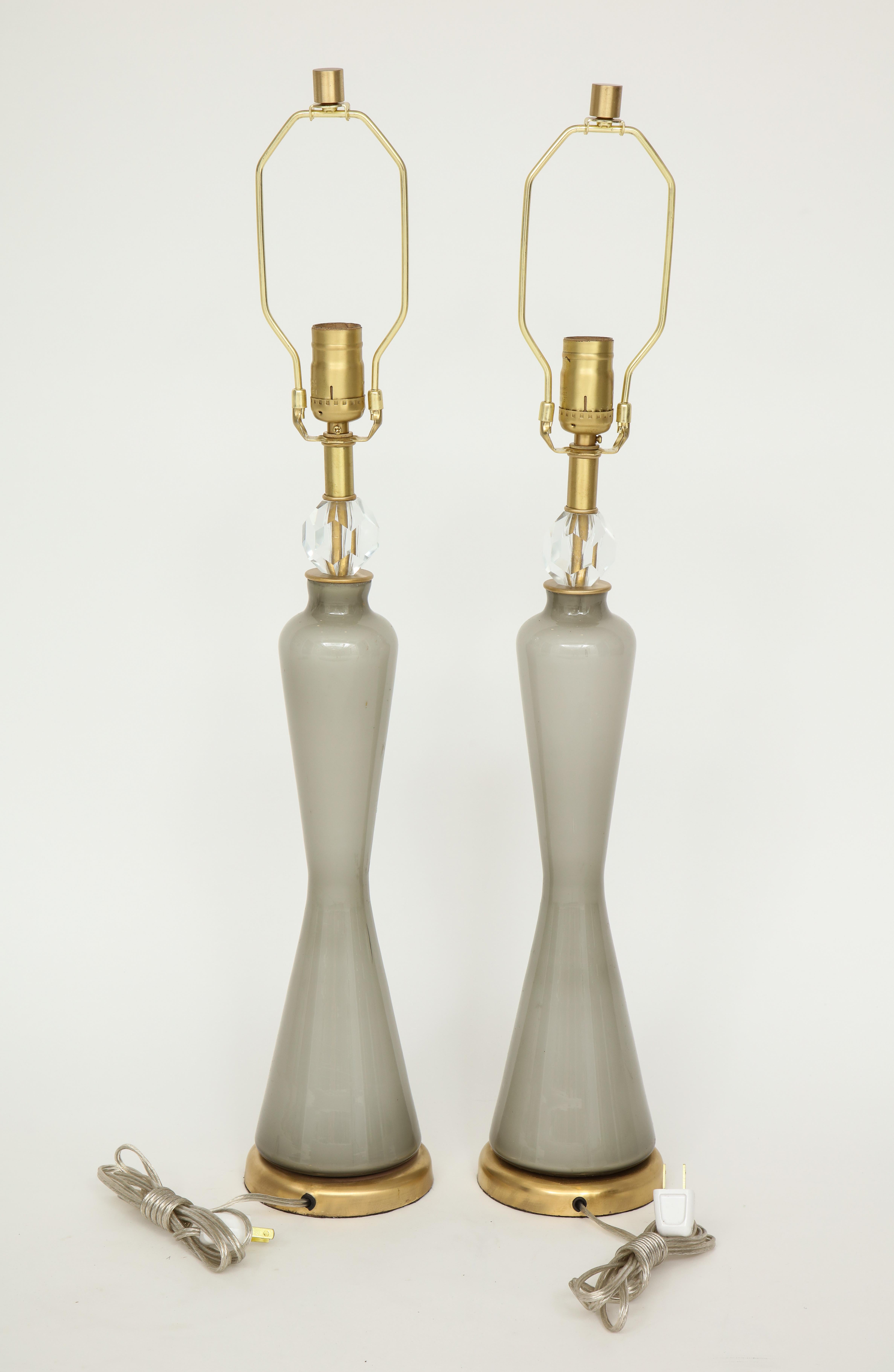 Pair of grey over white Murano glass lamps with a sinuous shaped body on brushed brass bases and faceted crystal collars. Rewired for use in the USA. 100W max bulbs. Glass measures 17.5 inches.